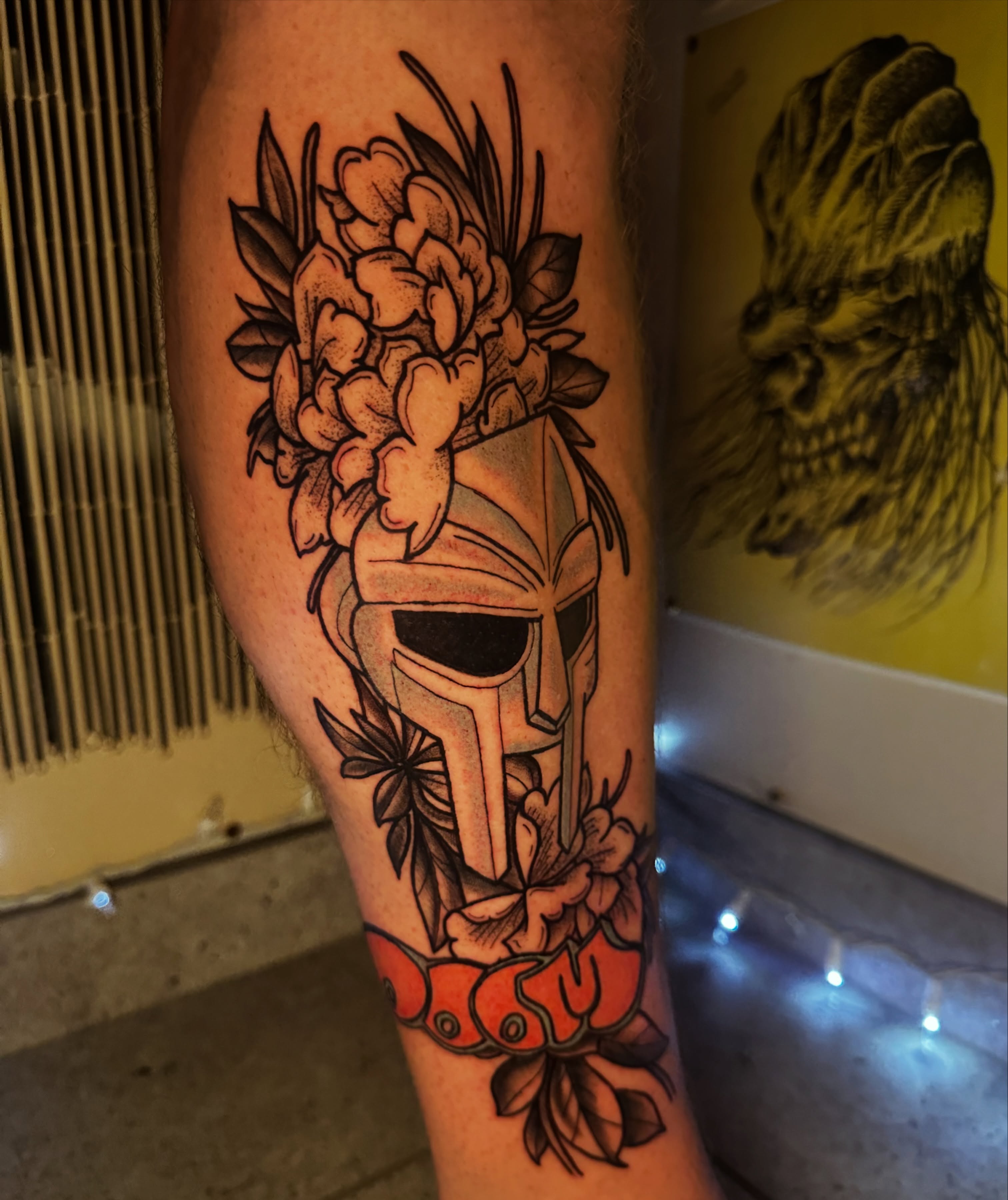 Spartan helmet with flowers American traditional tattoo on the forearm by Drew’s Tattoos (NH)