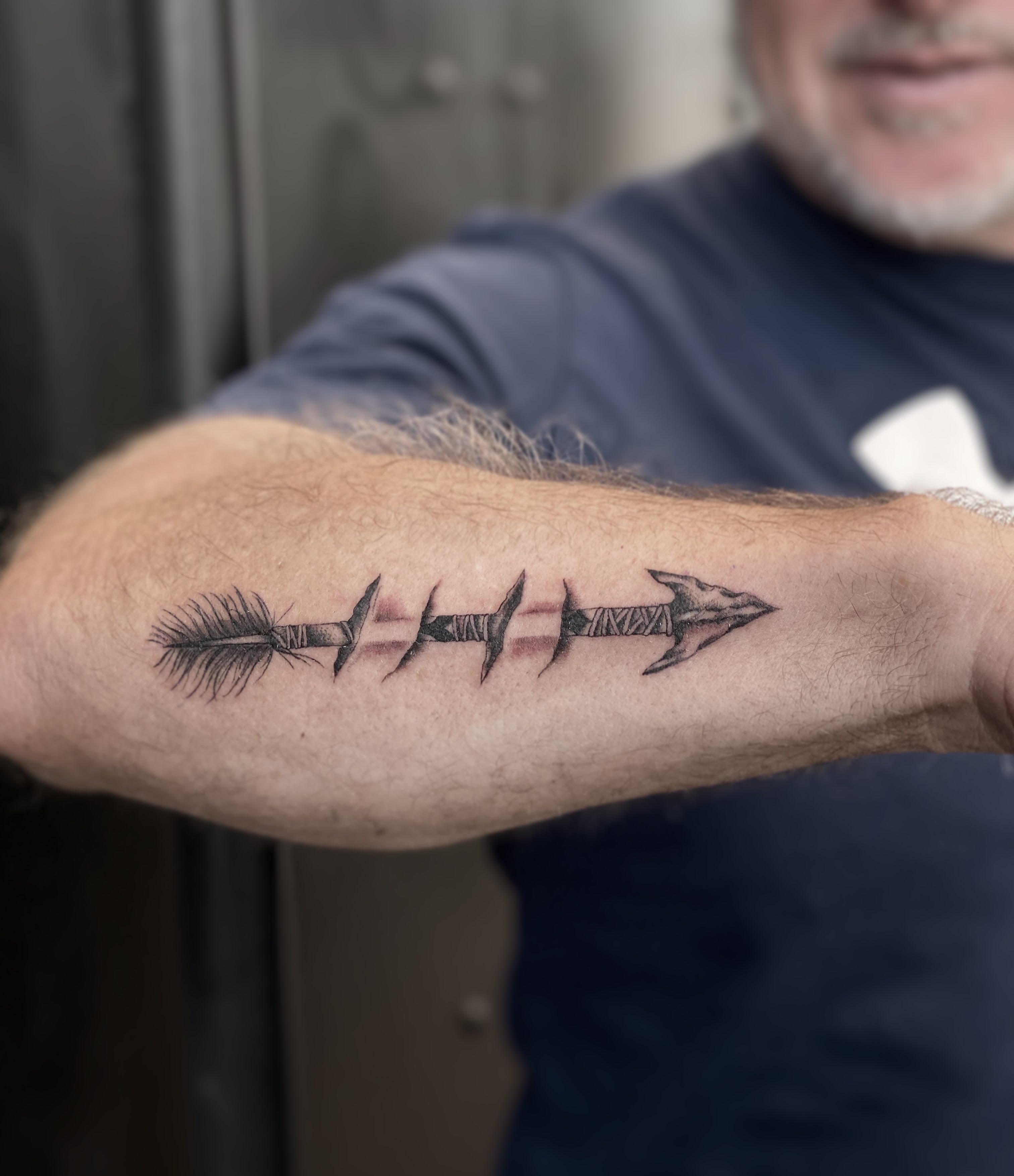 Arrow black and grey tattoo on the forearm by abbie michelle