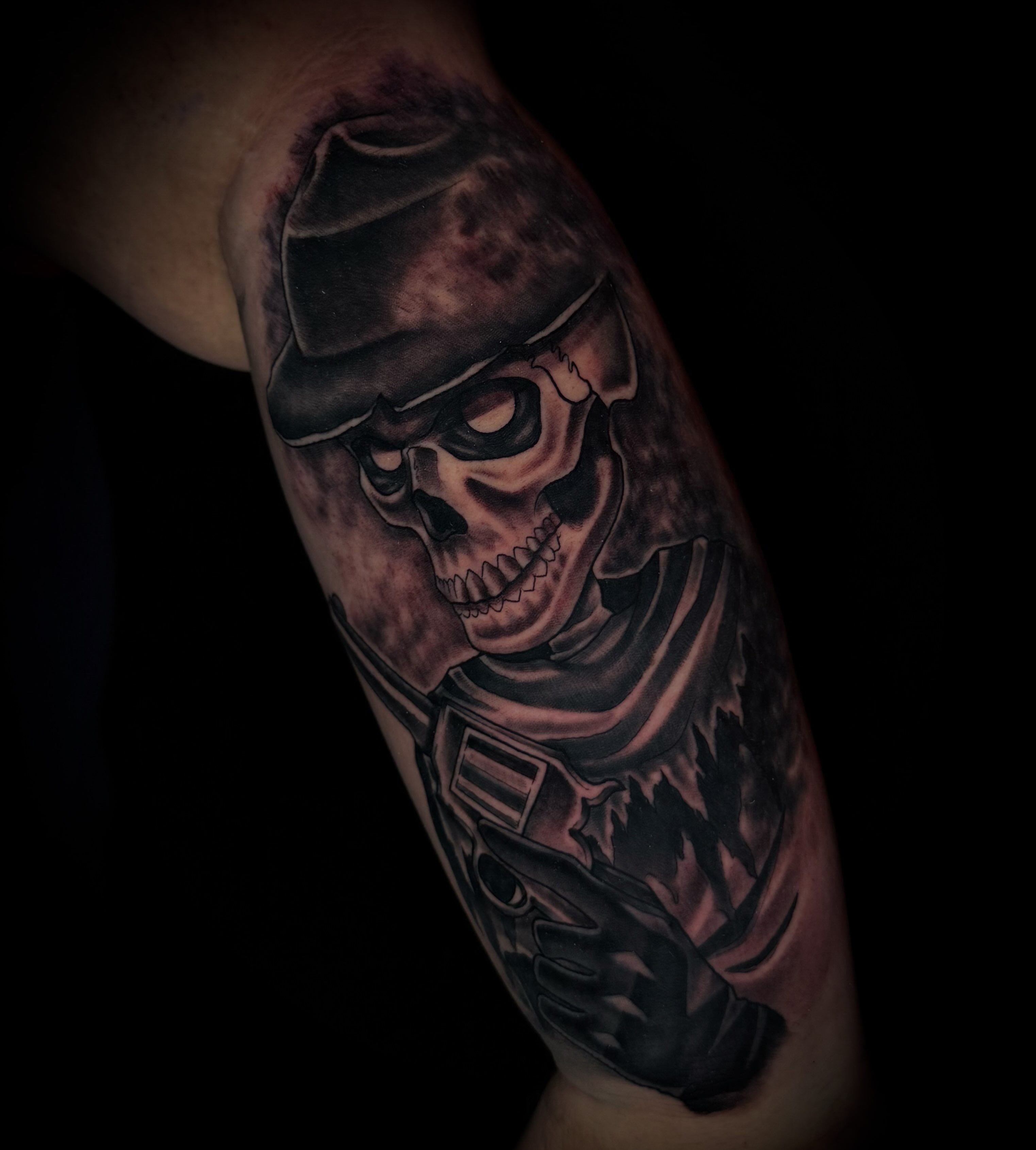 Skull wearing helmet dark realism tattoo on the forearm by Savannah Duff