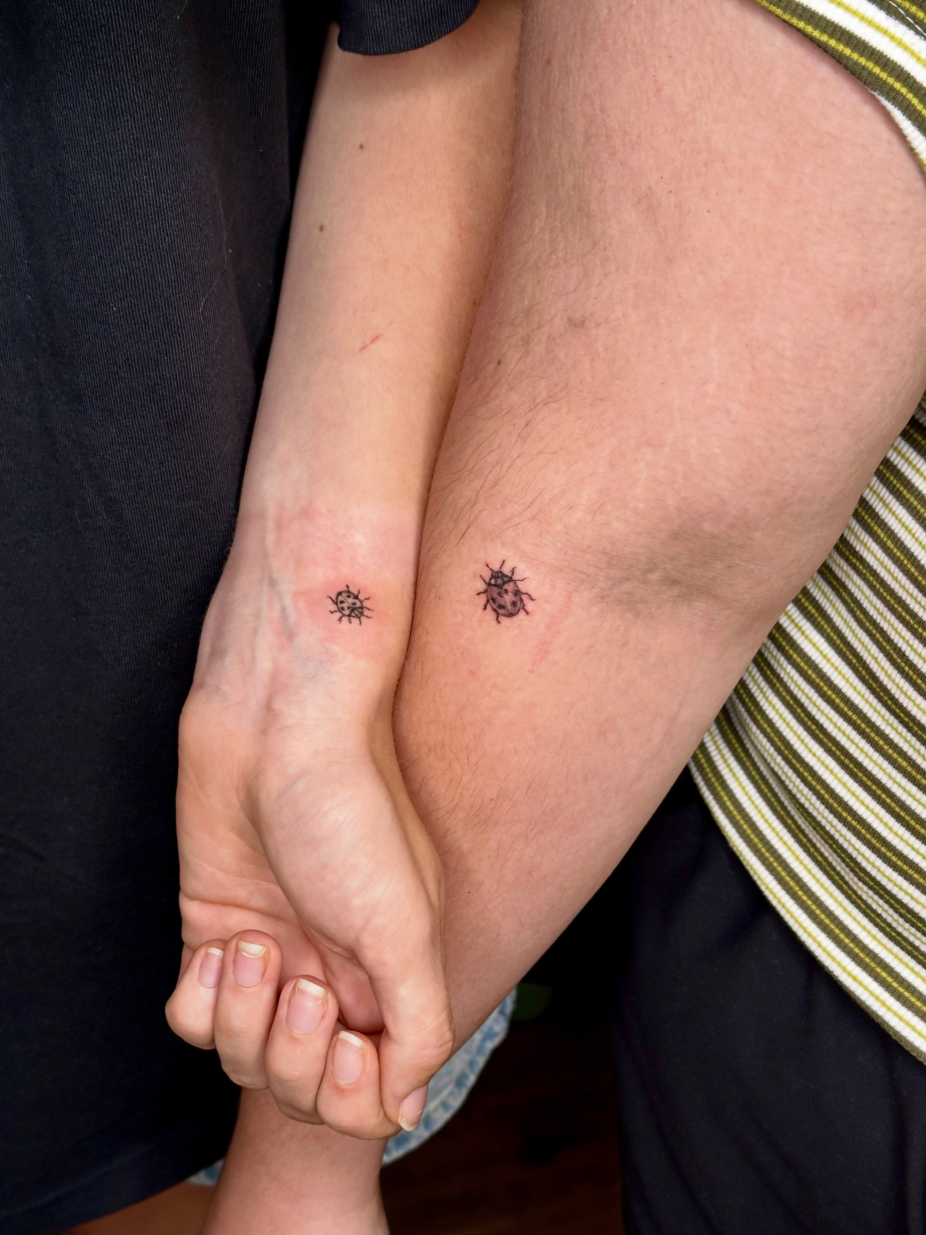 Ladybug black and grey tattoo on the forearm by Liz