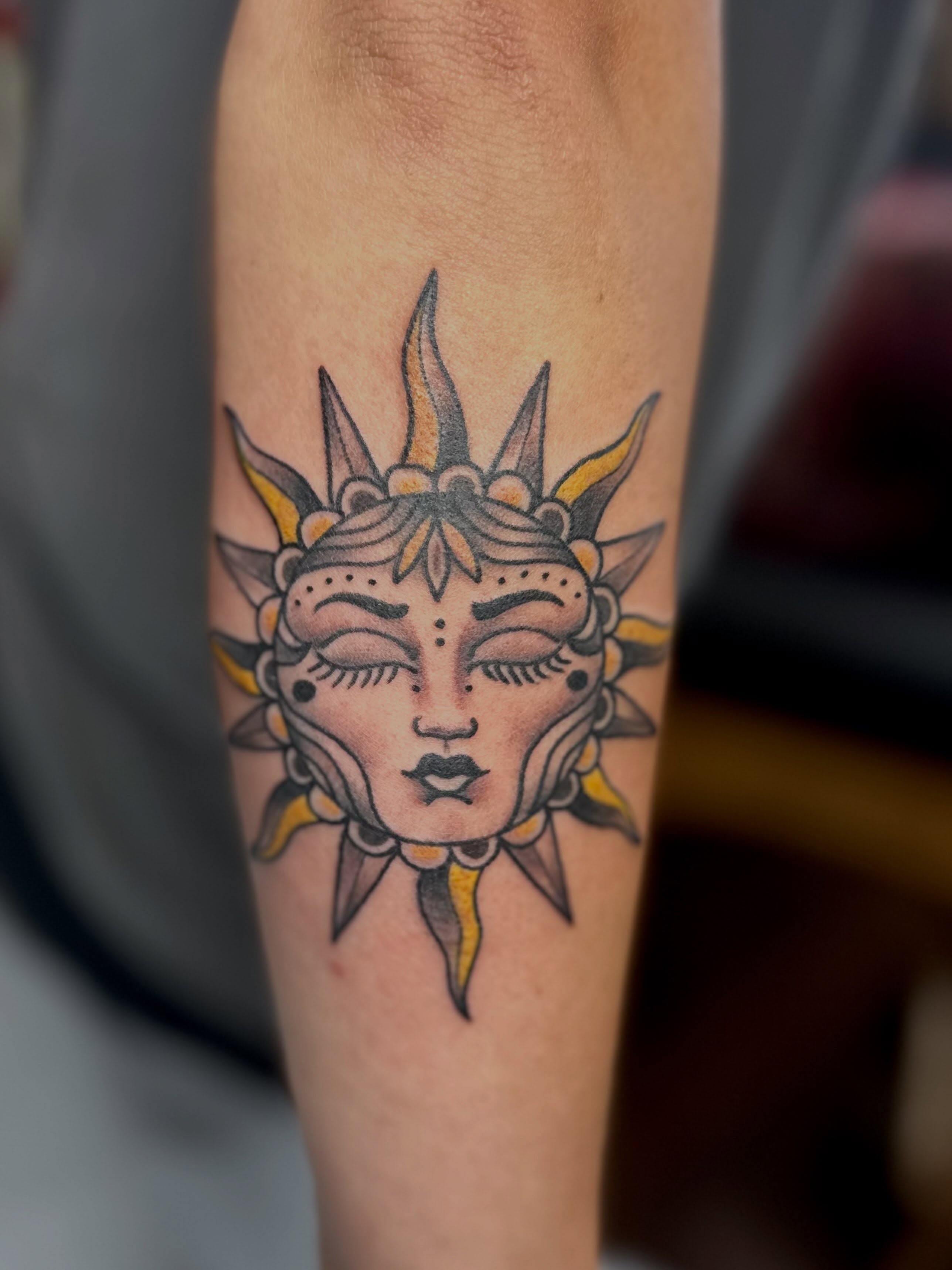 Sun face American traditional tattoo on the forearm by Dorrough Tattooer