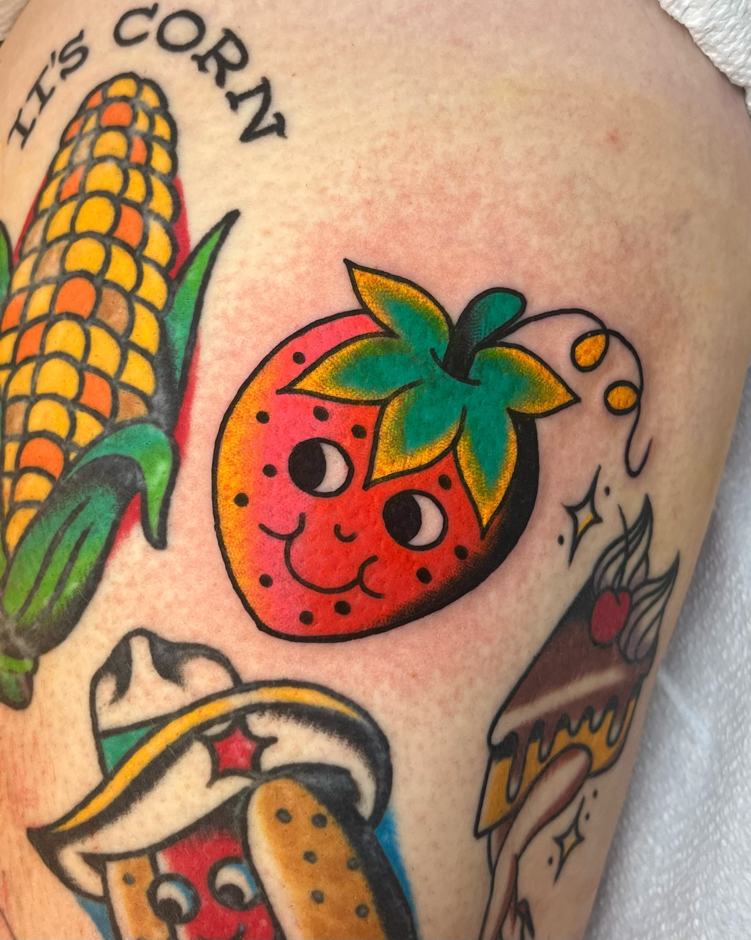 Strawberry American traditional tattoo on the thigh by Em Adkins
