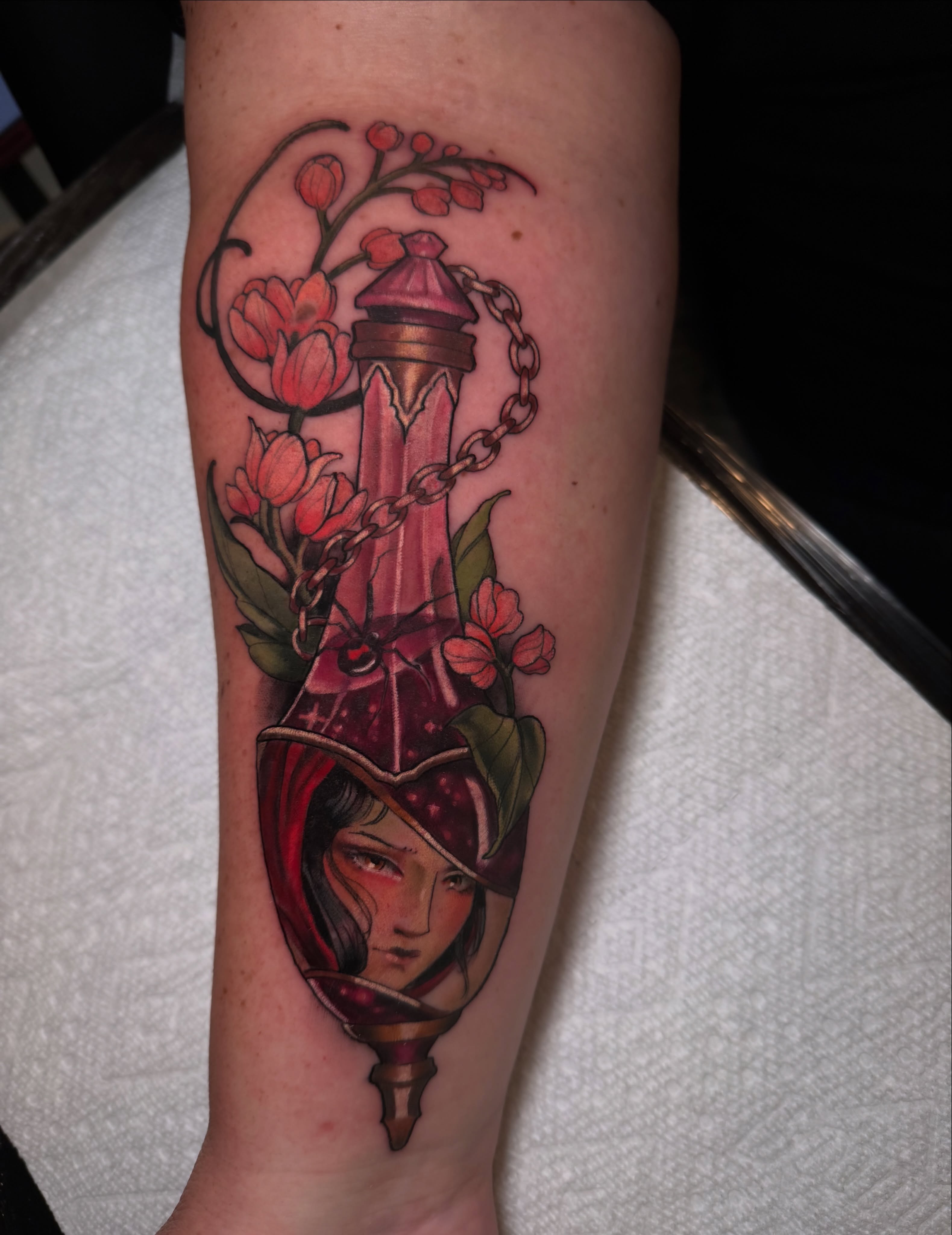 Glass bottle with woman's face realism tattoo on the forearm by Hannah Mckee