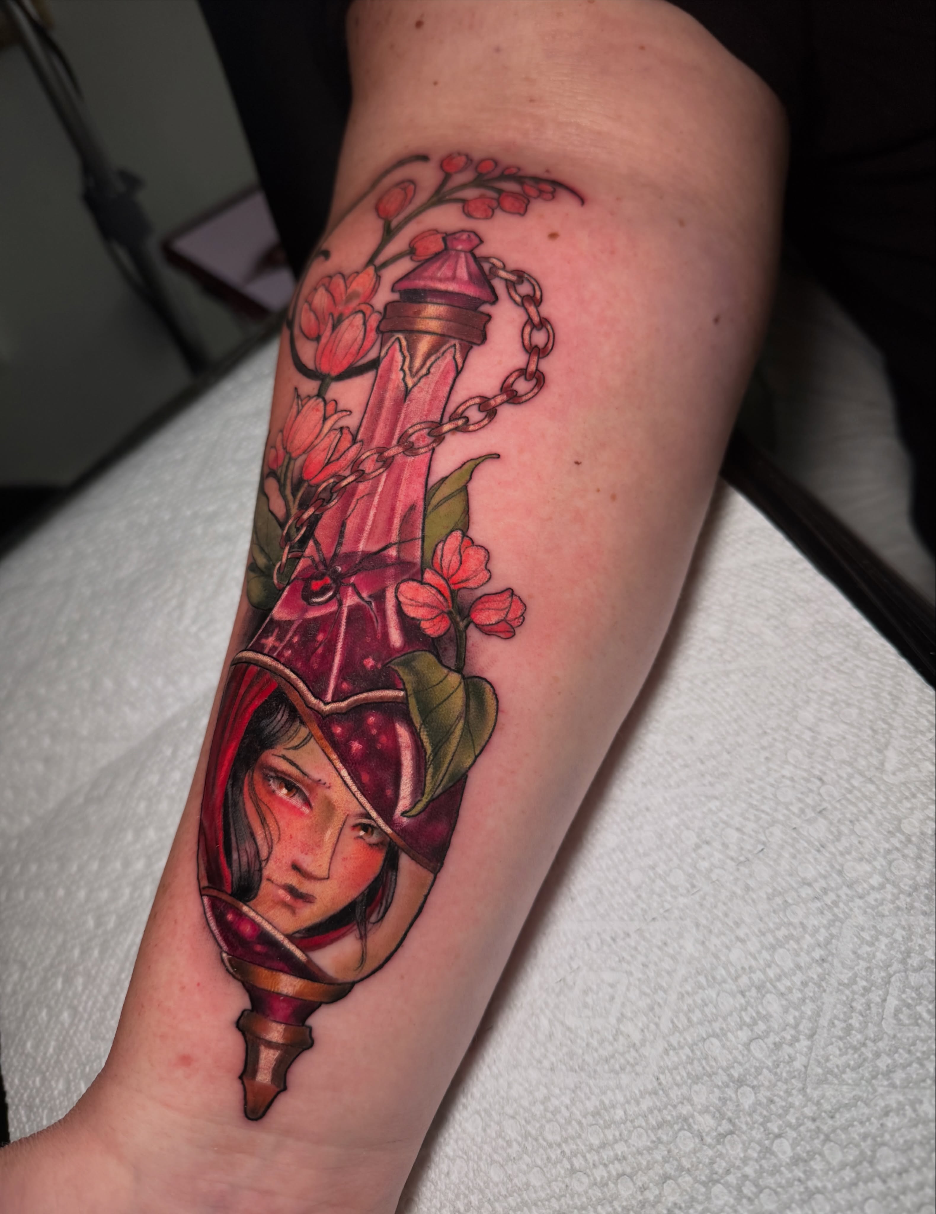 Woman's face in a lantern realism tattoo on the forearm by Hannah Mckee