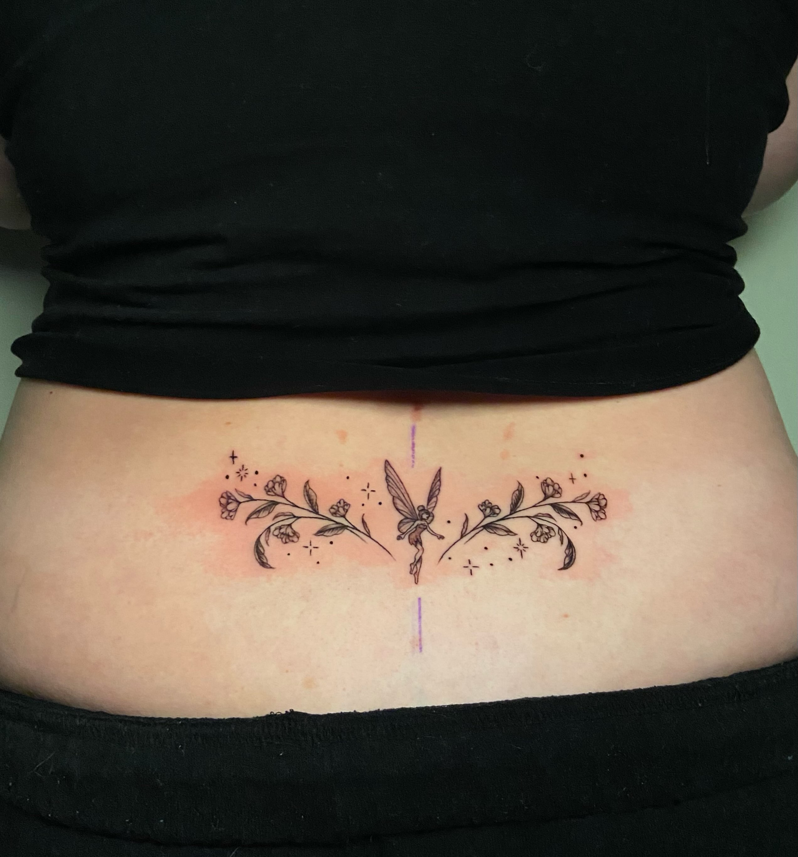 Fairy and floral dotwork tattoo on the torso by Ezra Gonda