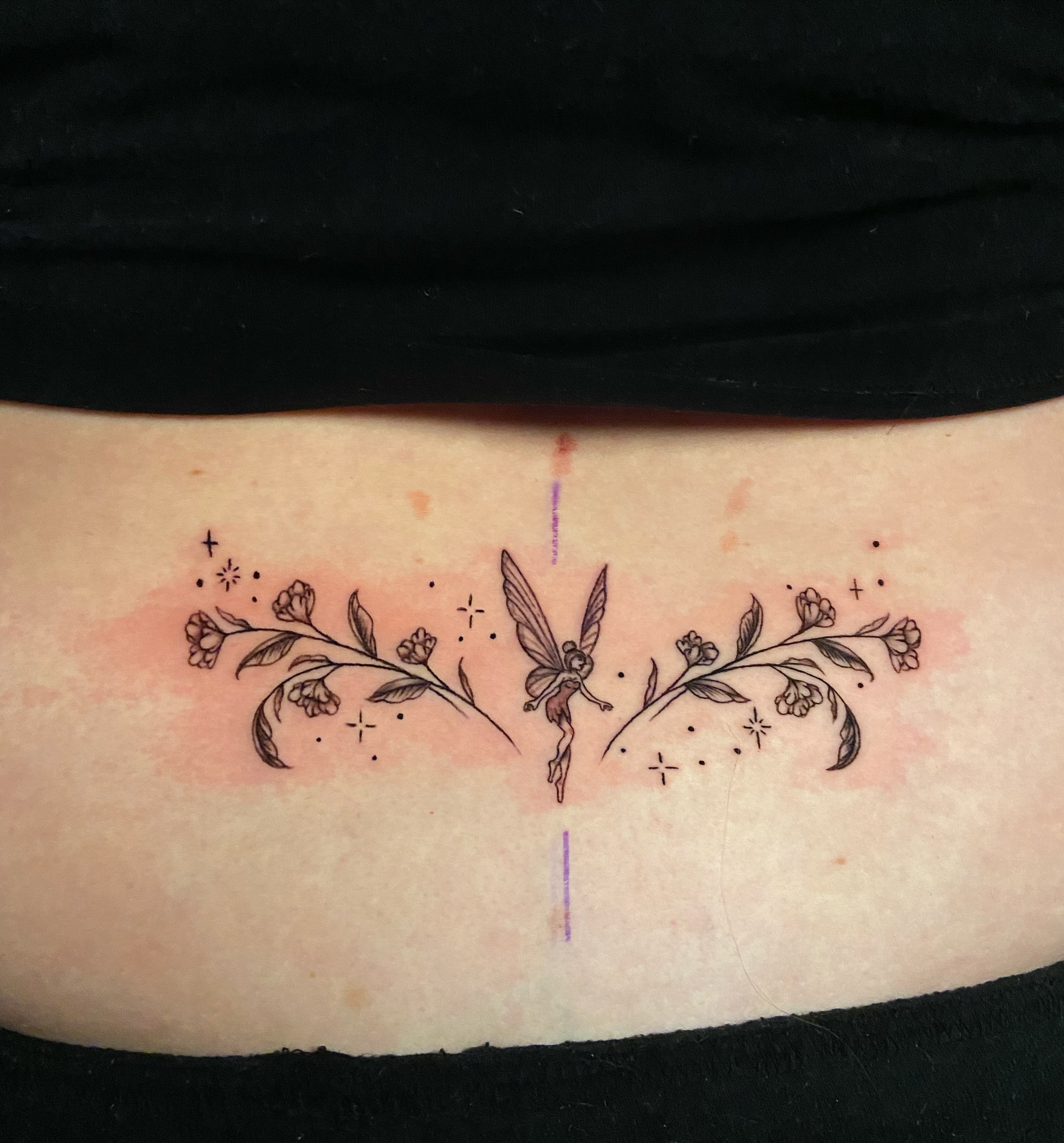 Fairy and floral dotwork tattoo on the ribs by Ezra Gonda
