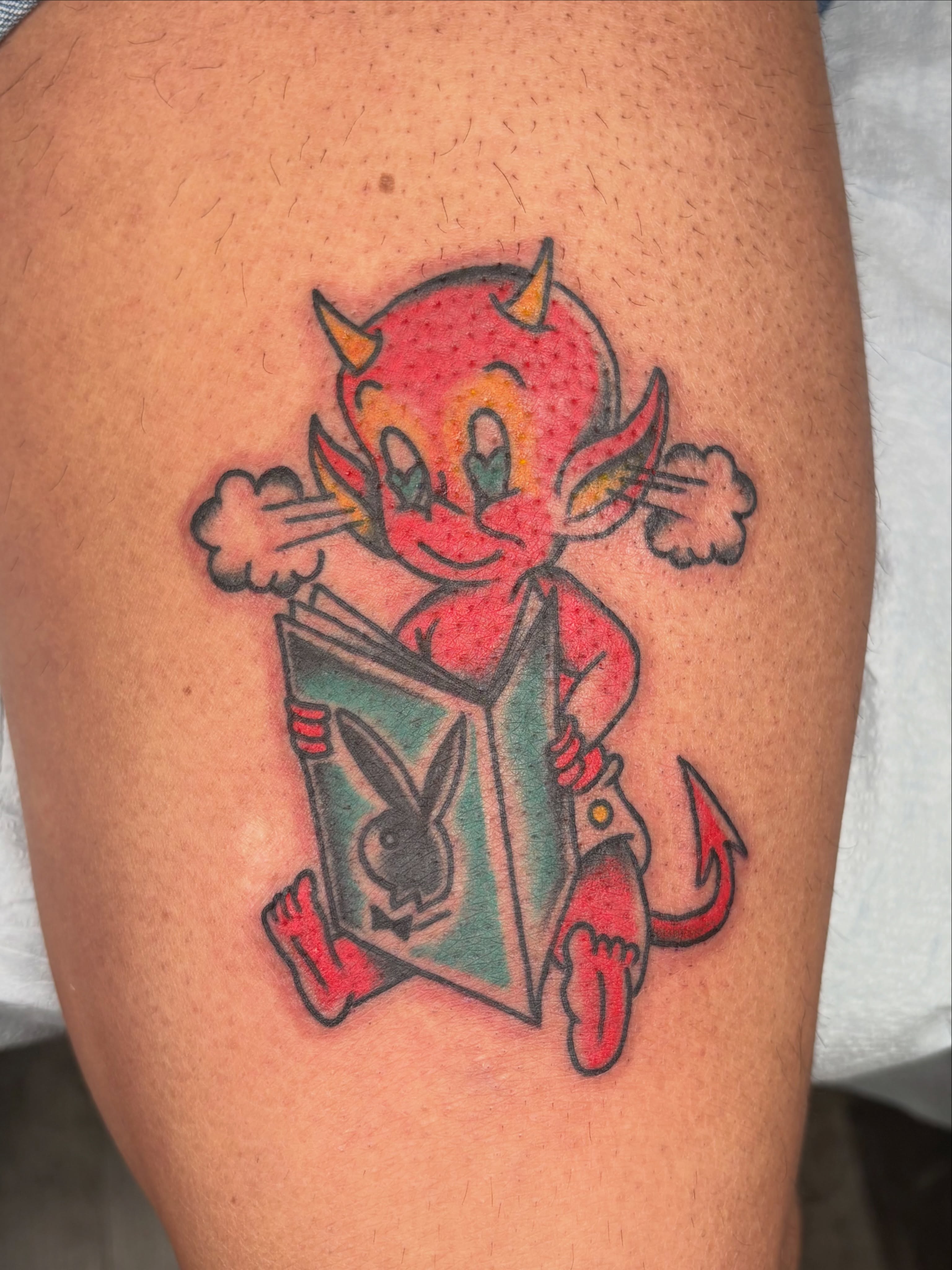 Devil reading Playboy American traditional tattoo on the thigh by Aysia Mankin-Wong, San Francisco, California