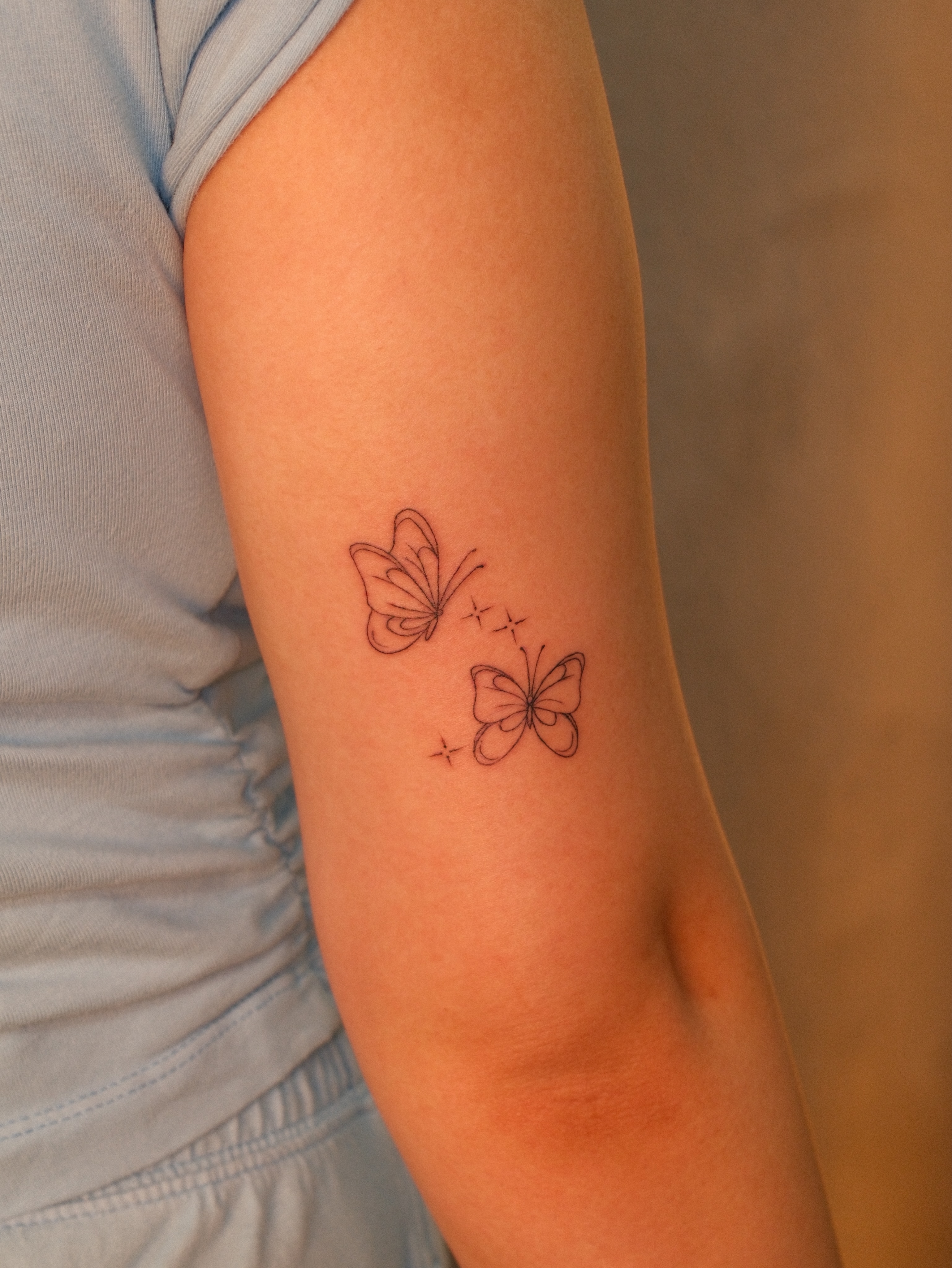 Butterflies fine line tattoo on the forearm by Luisa Duarte