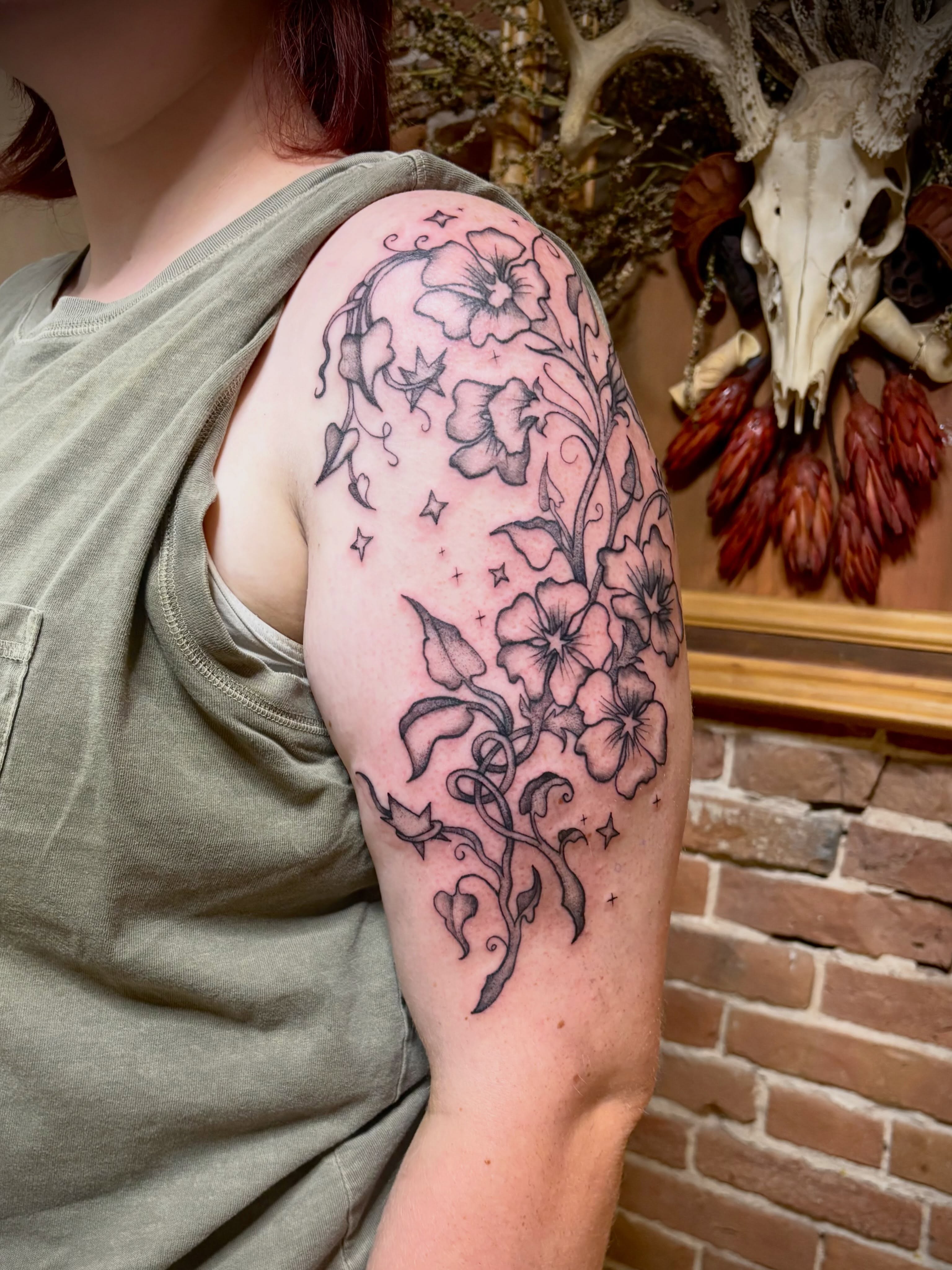 Floral bouquet black and grey tattoo on the upper arm by Tattoo Artist, Kansas City, Missouri