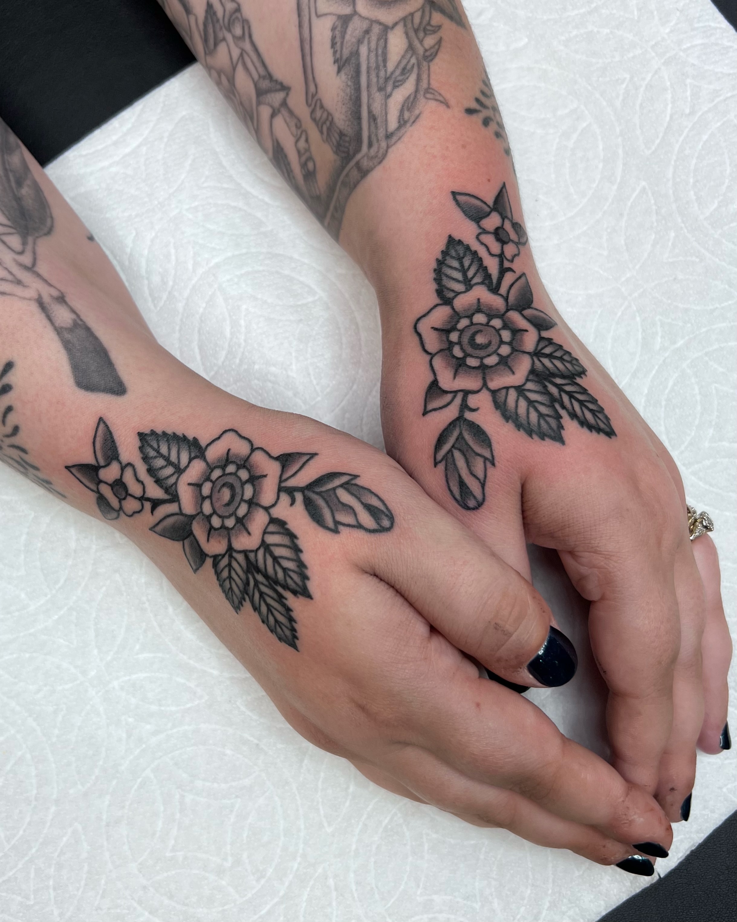 Floral arrangement black and grey tattoo on the hand by Brian Visser
