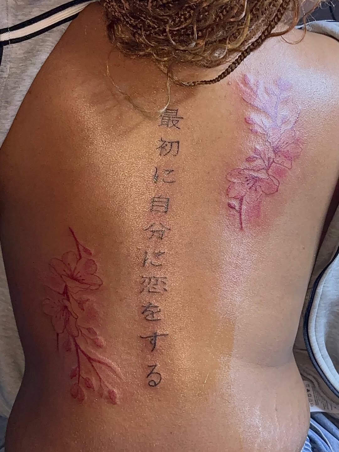 Japanese script and cherry blossoms tattoo on the back by GasPaccInk