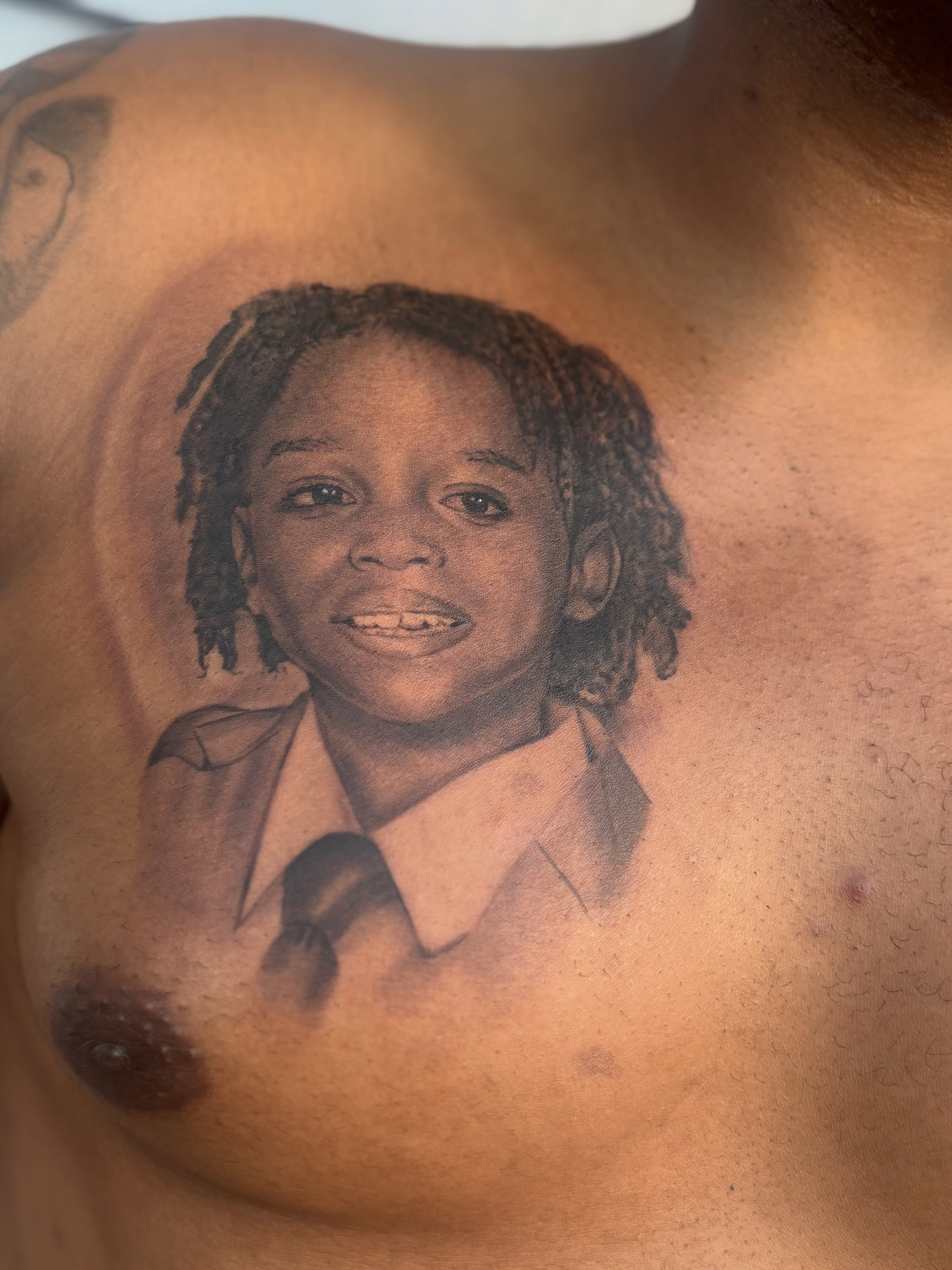 Portrait realism tattoo on the chest by Russell B