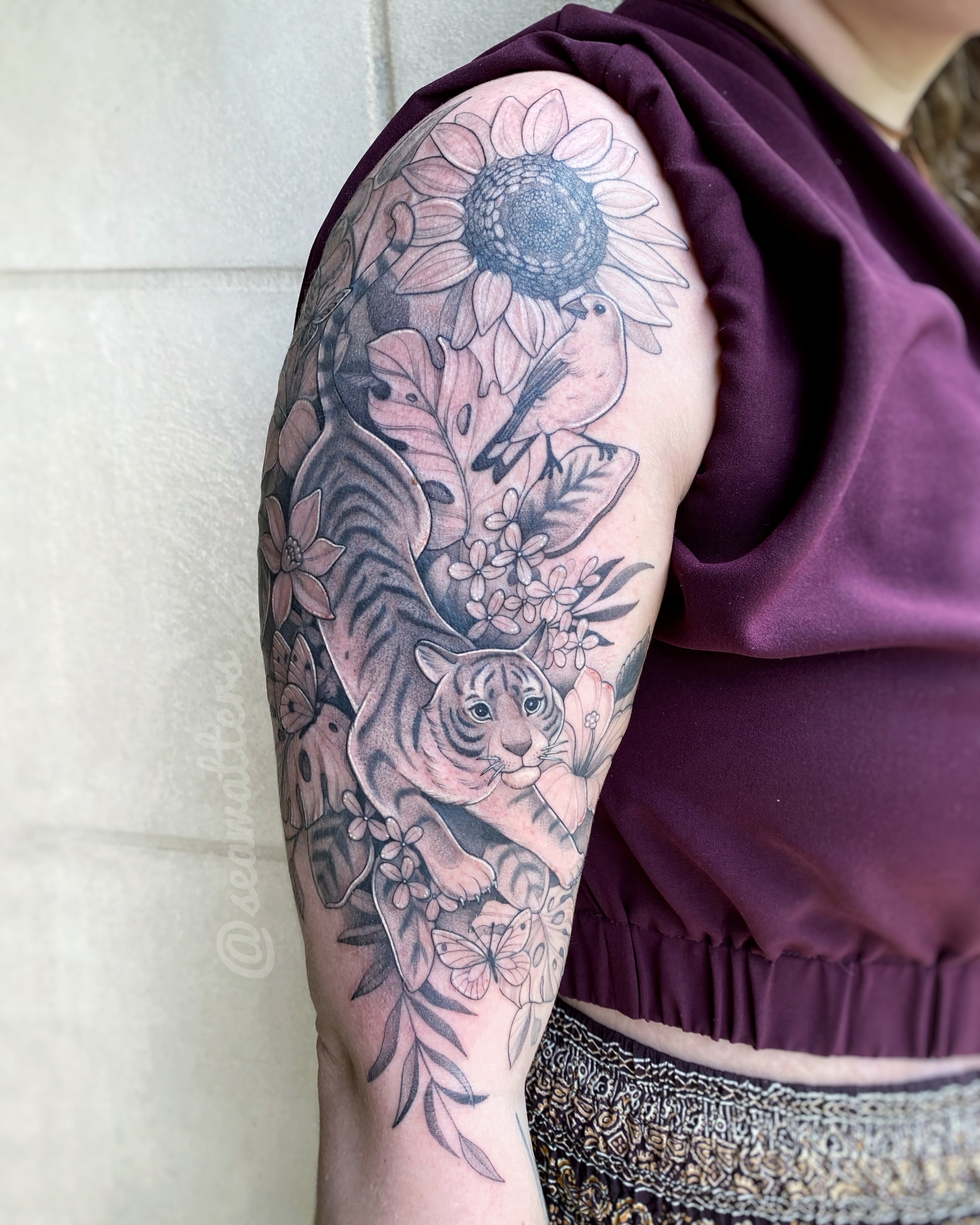 Tiger and sunflower realism tattoo on the upper arm by Caitlin Watters