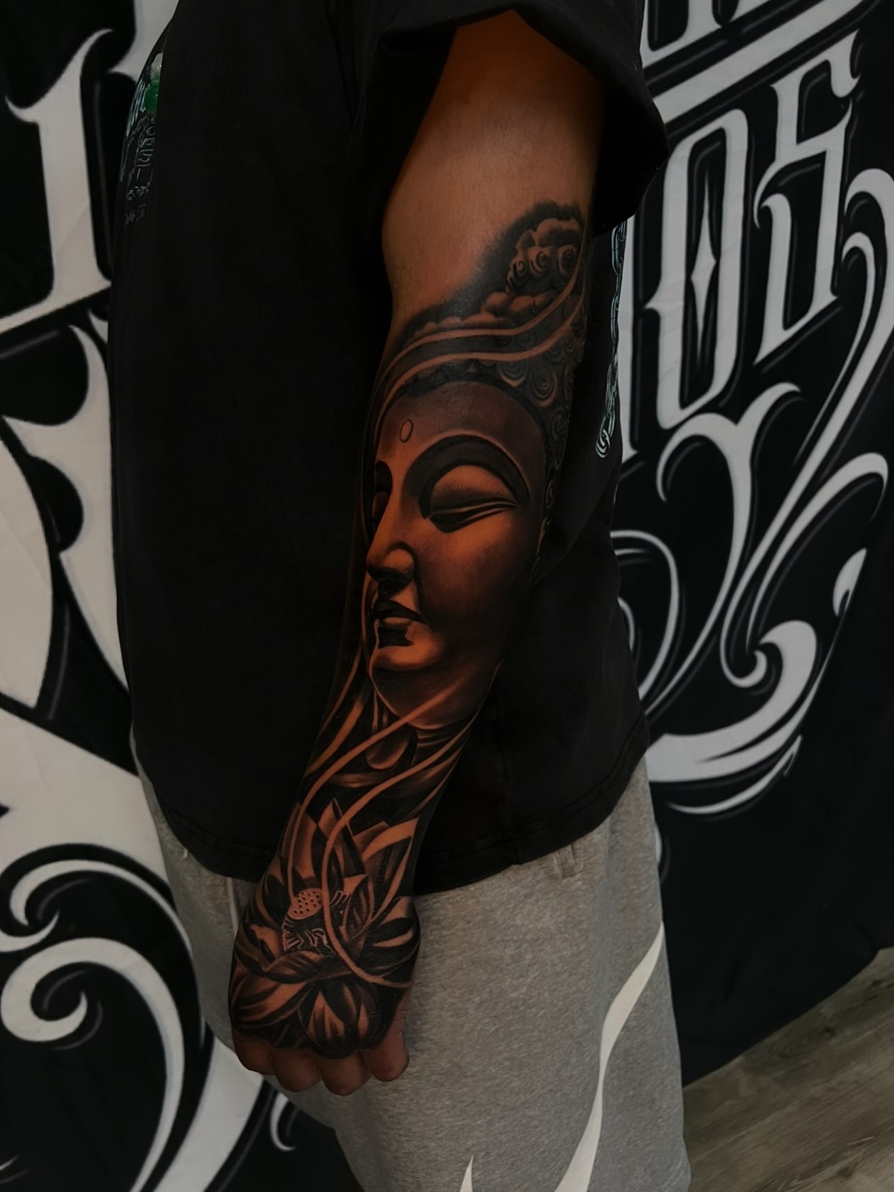 Buddha head realism tattoo on the forearm by Daniel Michael Perez