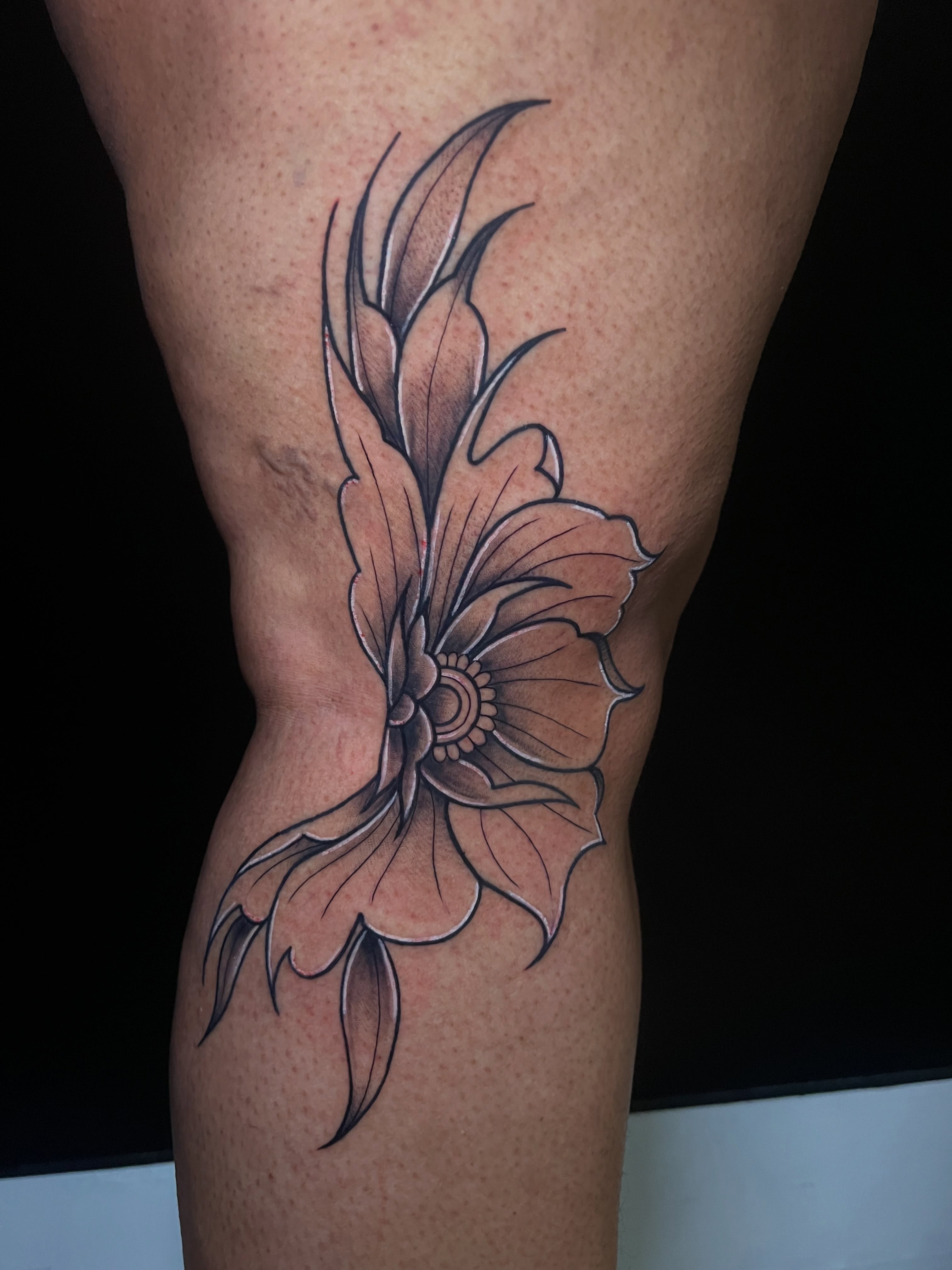 Flower black and grey tattoo on the thigh by Baung Ben