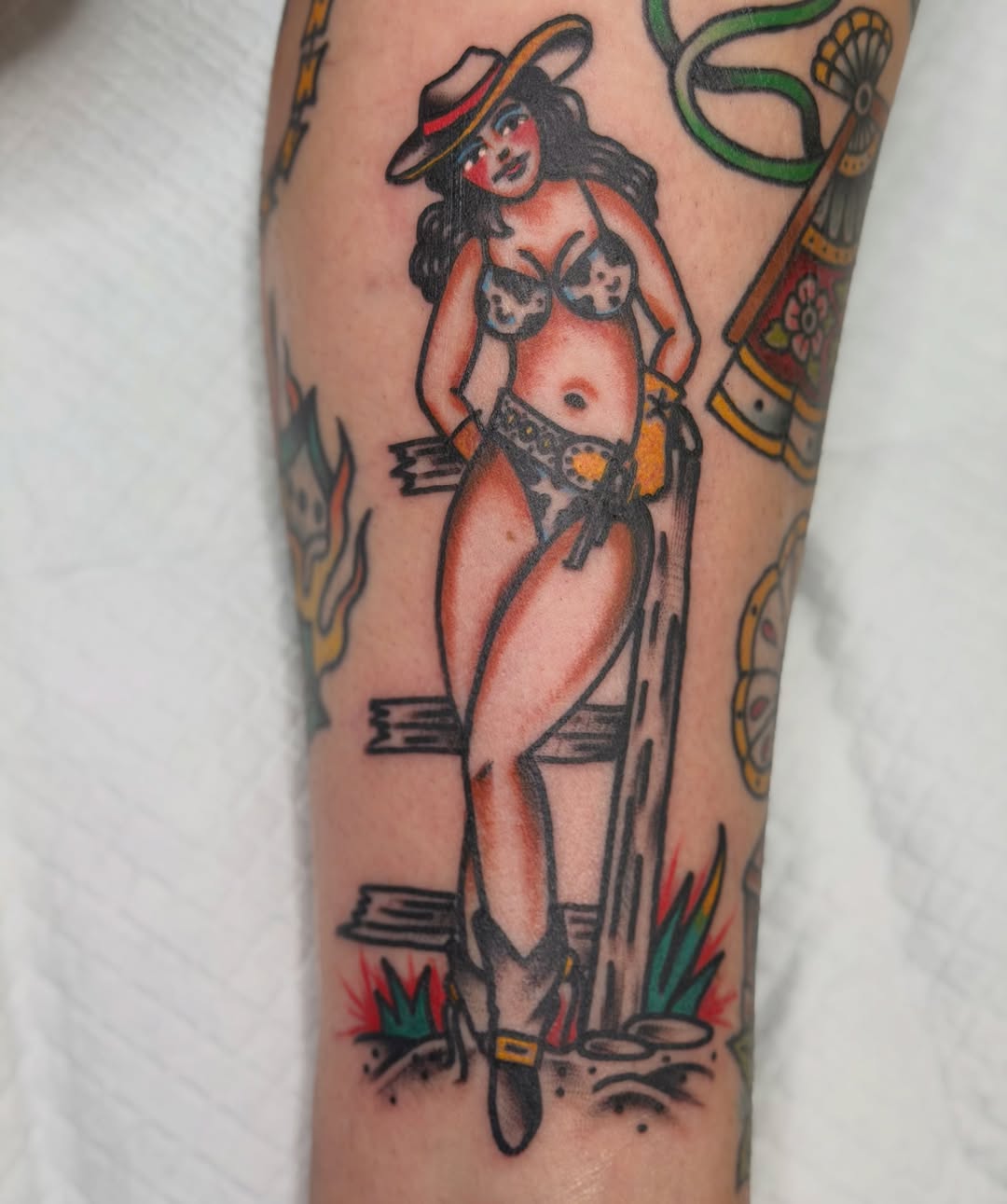 Pin-up girl American traditional tattoo on the forearm by dave rash