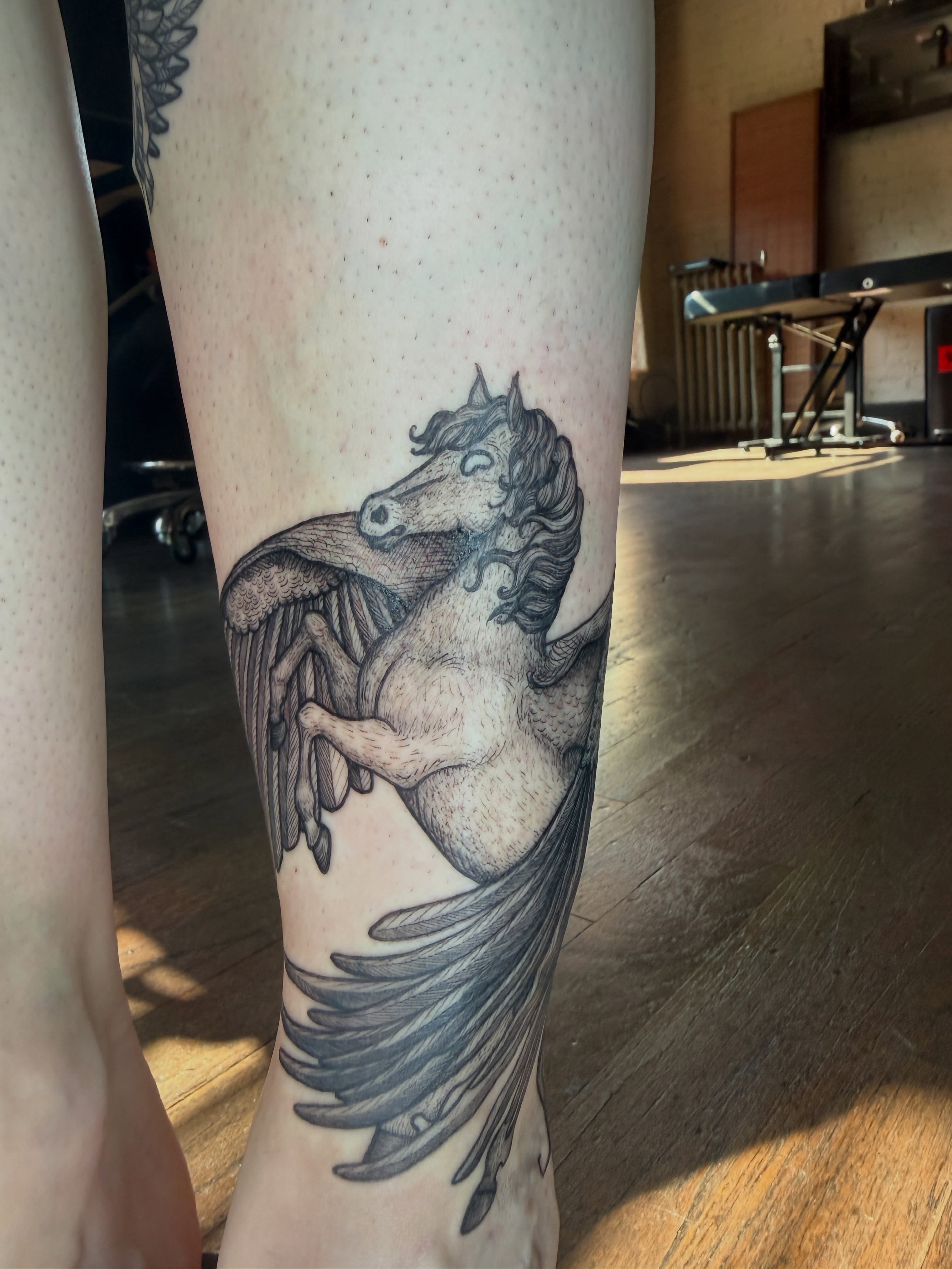Pegasus black and grey tattoo on the calf by Lora Bird