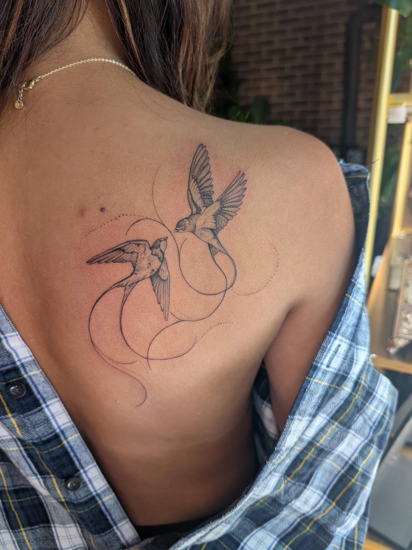 Swallows black and grey tattoo on the back by Arminda Walborn