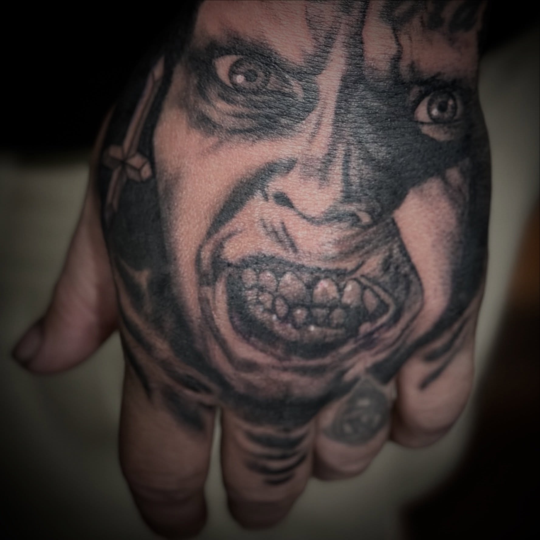 Angry face black and grey tattoo on the hand by Jason Oz, Denver, Colorado
