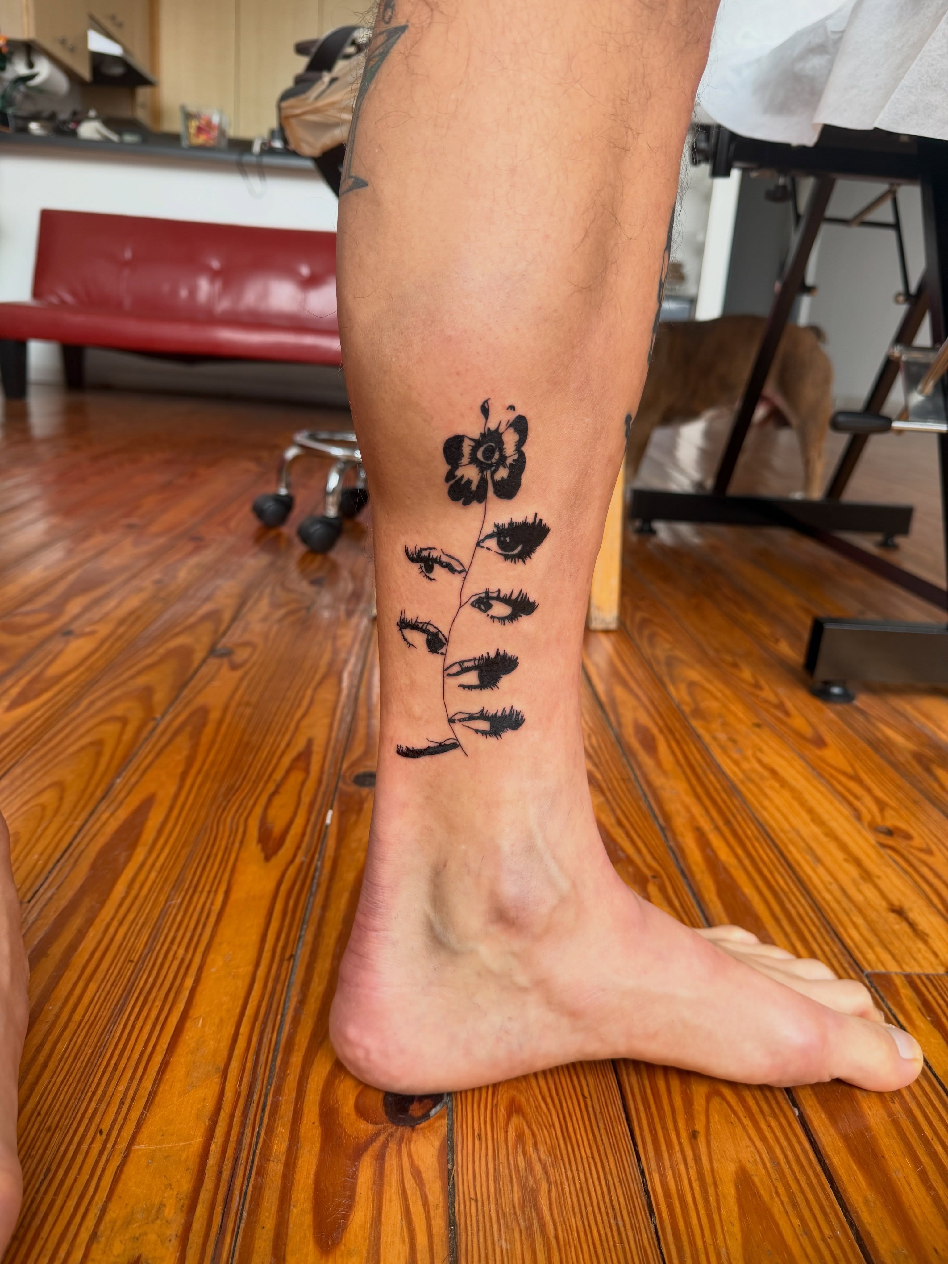 Flower and eyes black and grey tattoo on the calf by Jose Javier