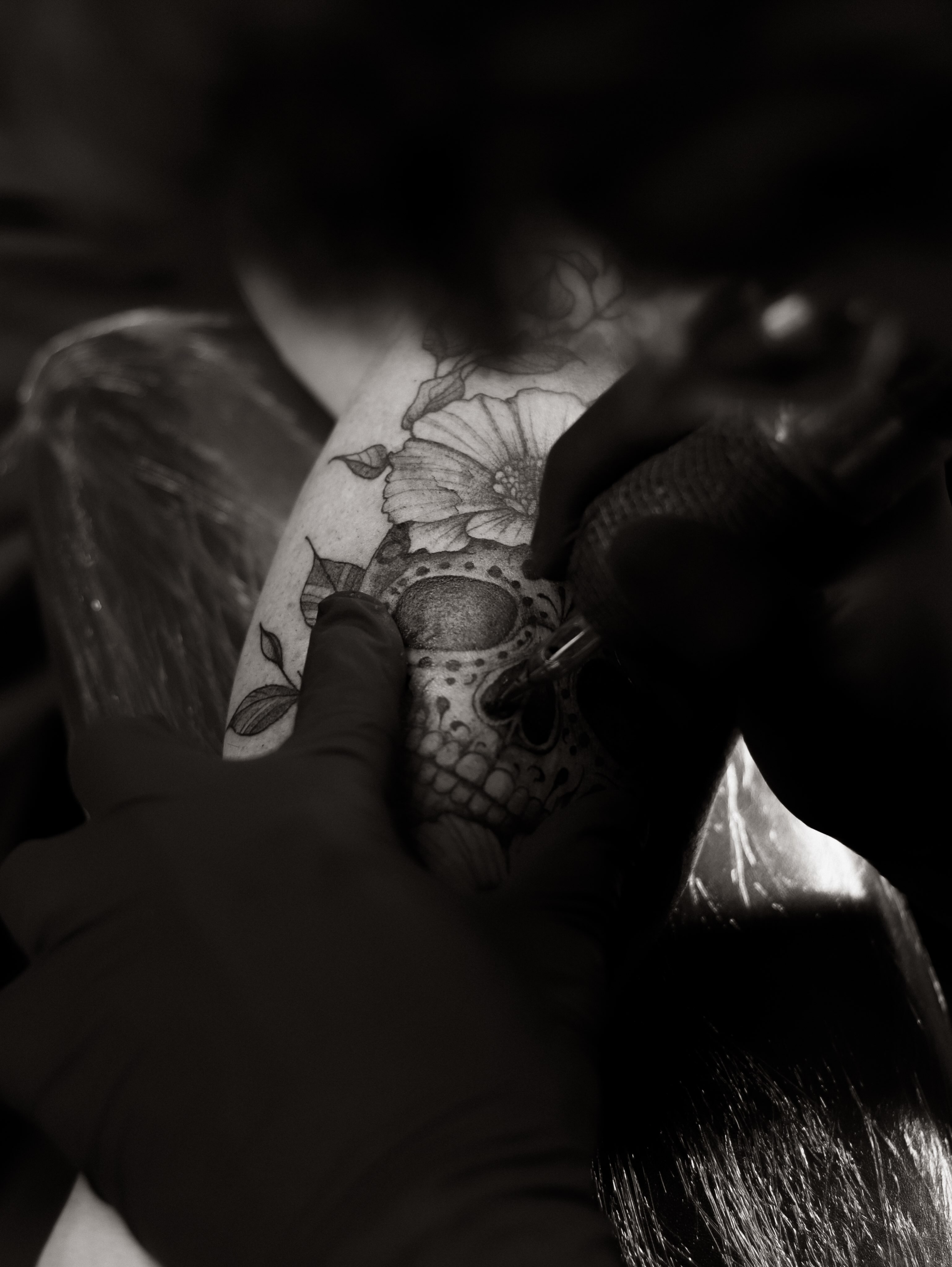 Skull with floral elements dotwork tattoo on the shoulder by Arthur Kossoski