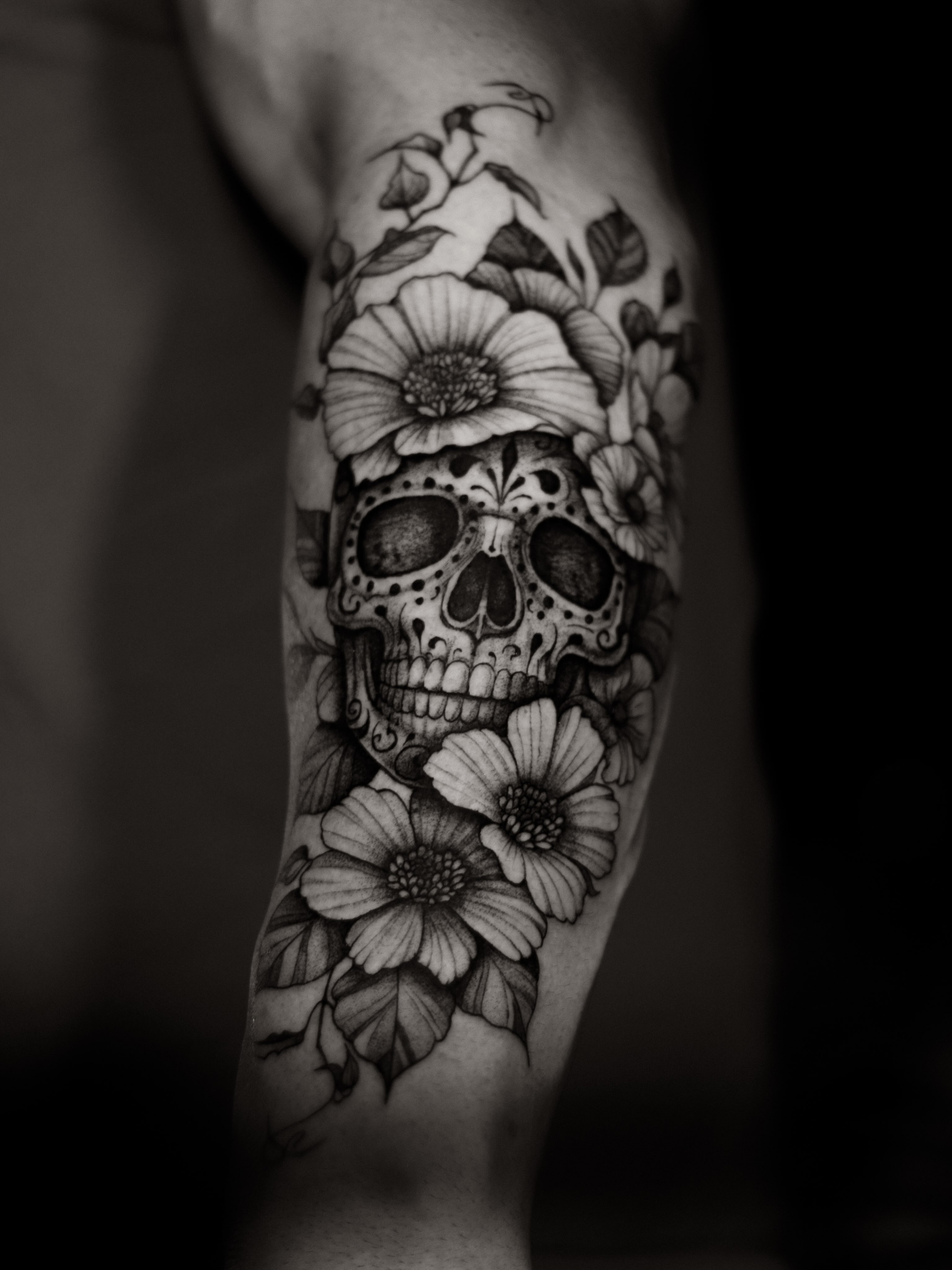 Skull and flowers realism tattoo on the forearm by Arthur Kossoski