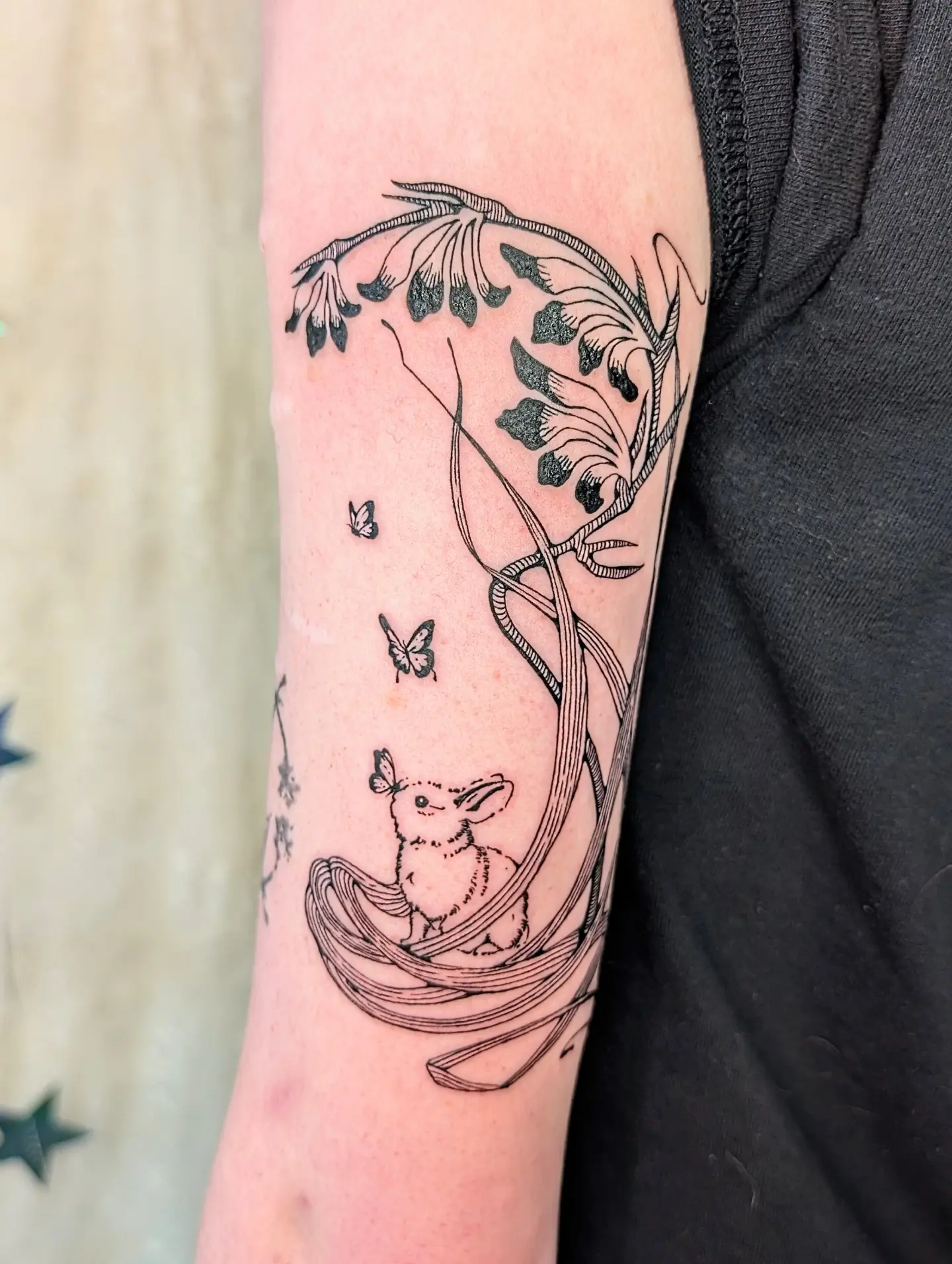 Rabbit and floral fine line tattoo on the forearm by mila