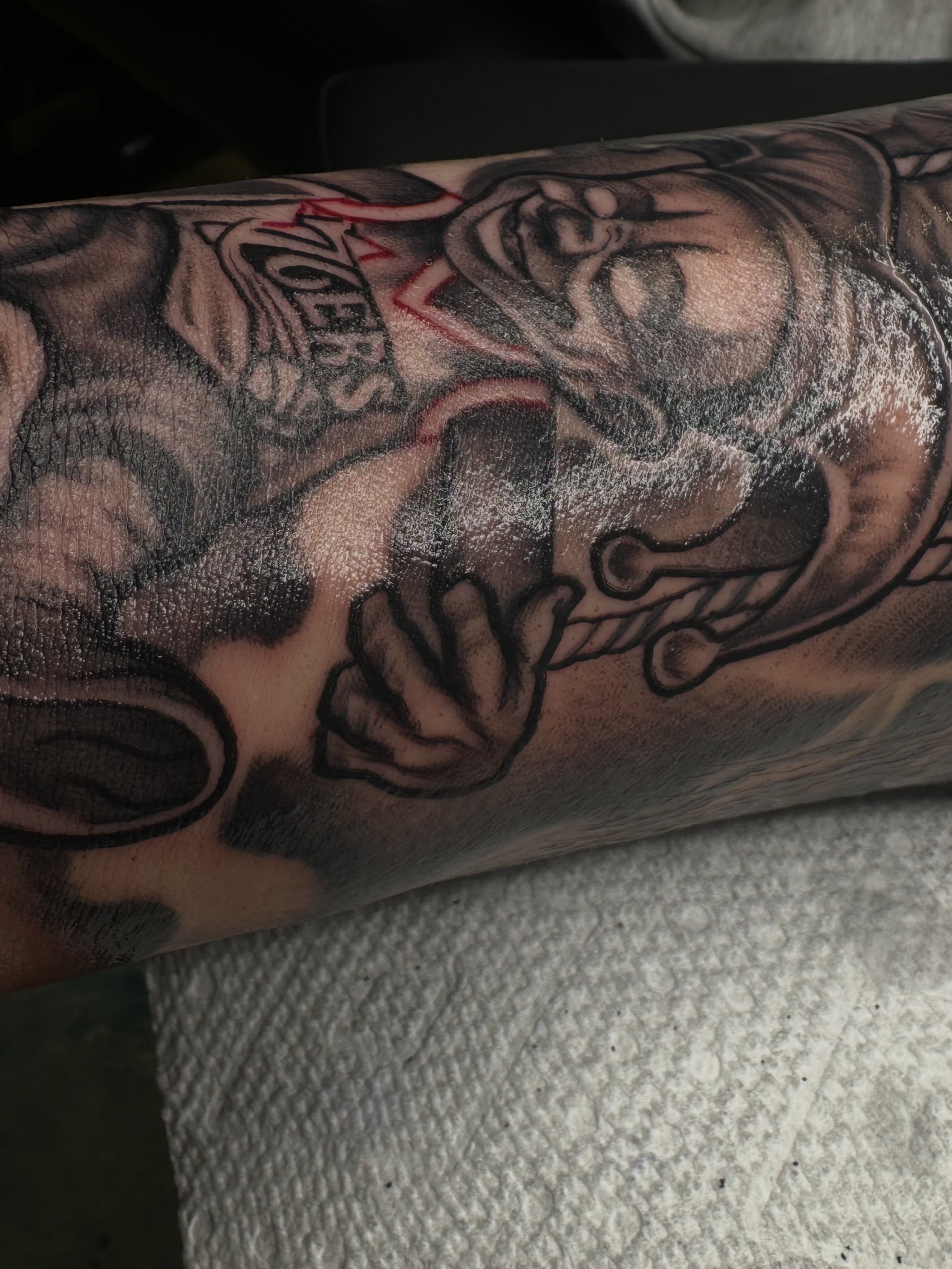 Man with beard and mustache black and grey tattoo on the forearm by Jay Daartist