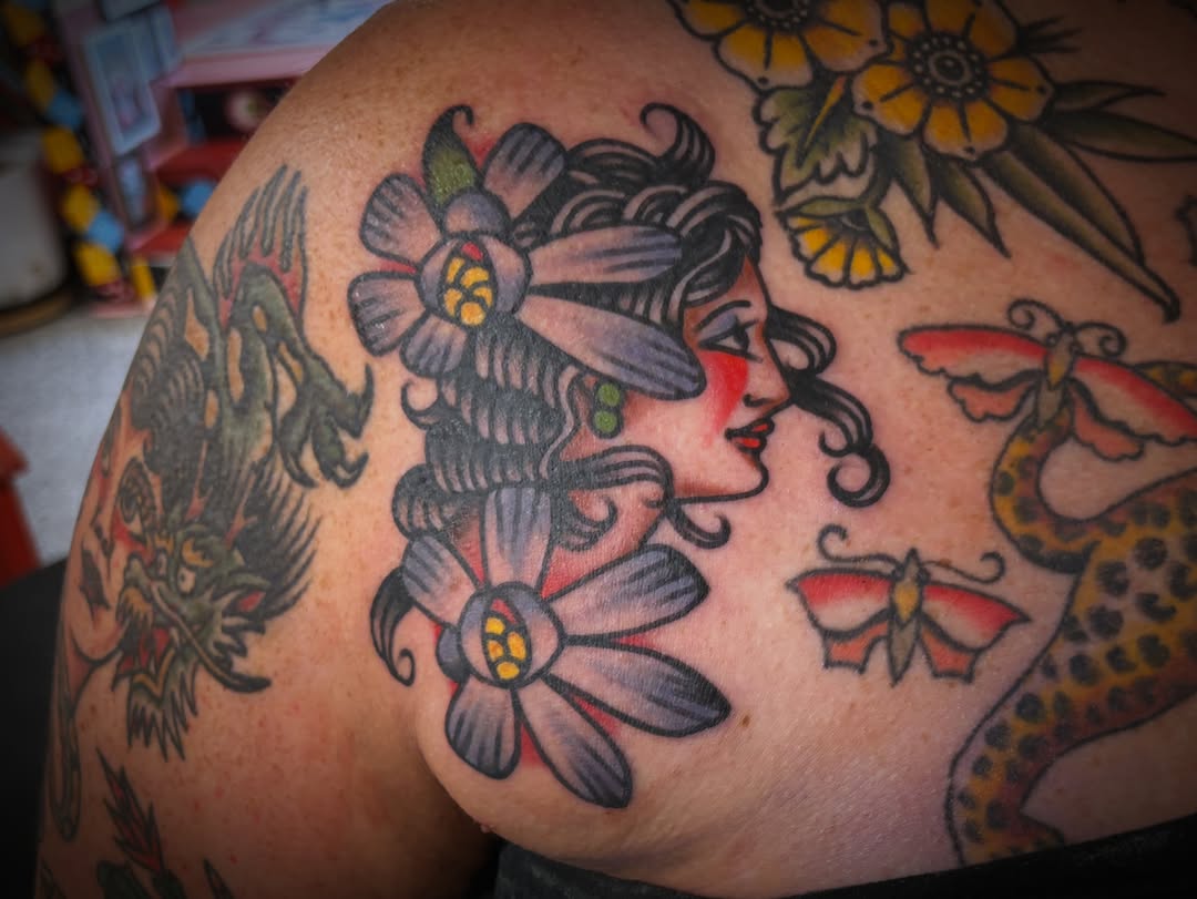Woman with flowers American traditional tattoo on the shoulder by Deya Aven, Nashville, Tennessee