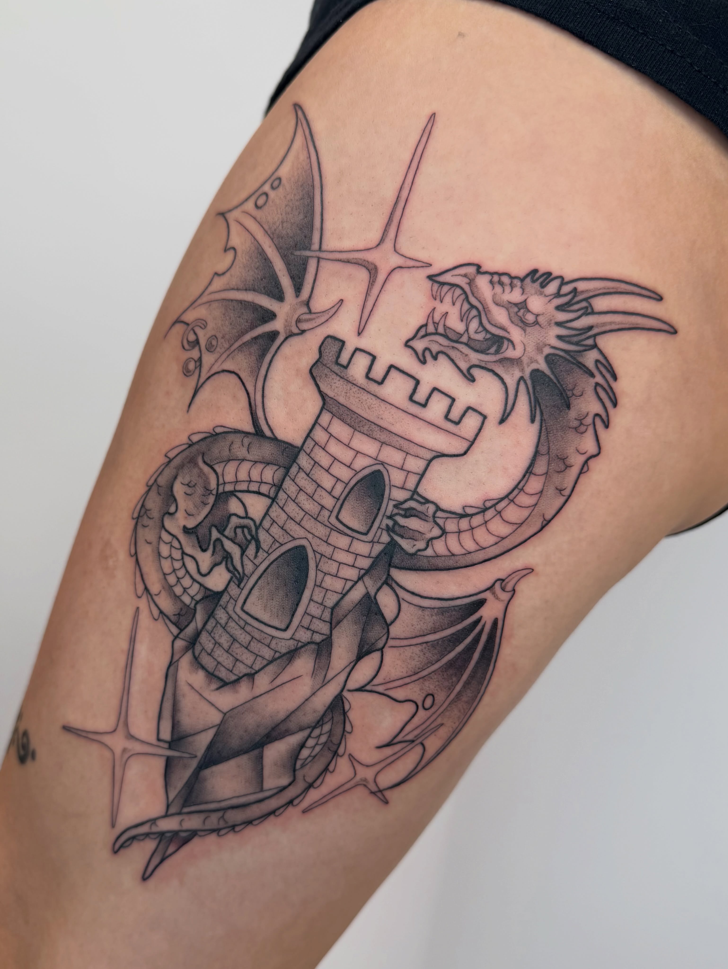Dragon and castle black and grey tattoo on the thigh by 𝔓𝔢𝔞𝔠𝔥𝔶 𝔄𝔫𝔰𝔩𝔢𝔶