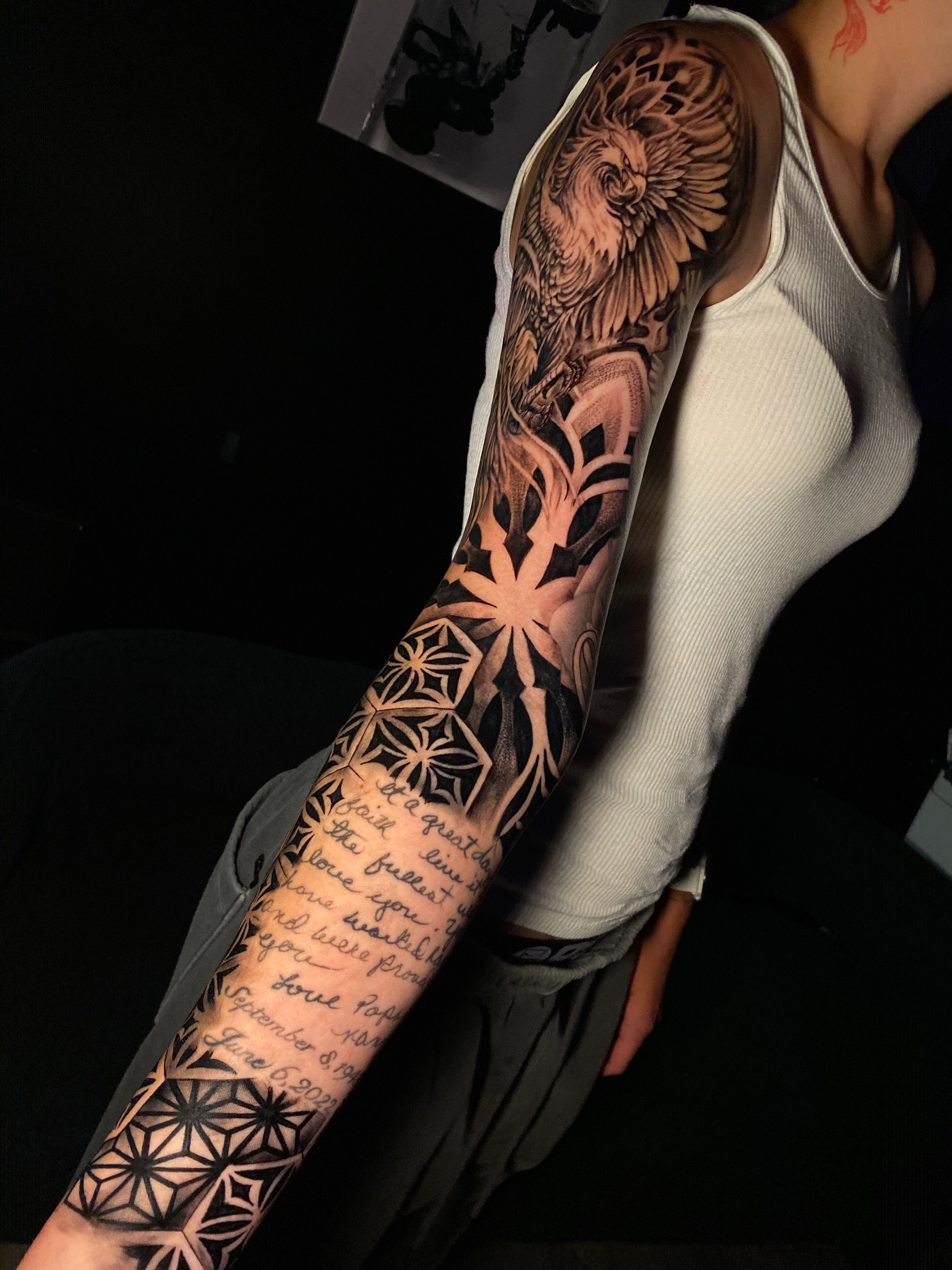 Lion and floral patterns geometric tattoo on the upper arm by Tattoo Artist