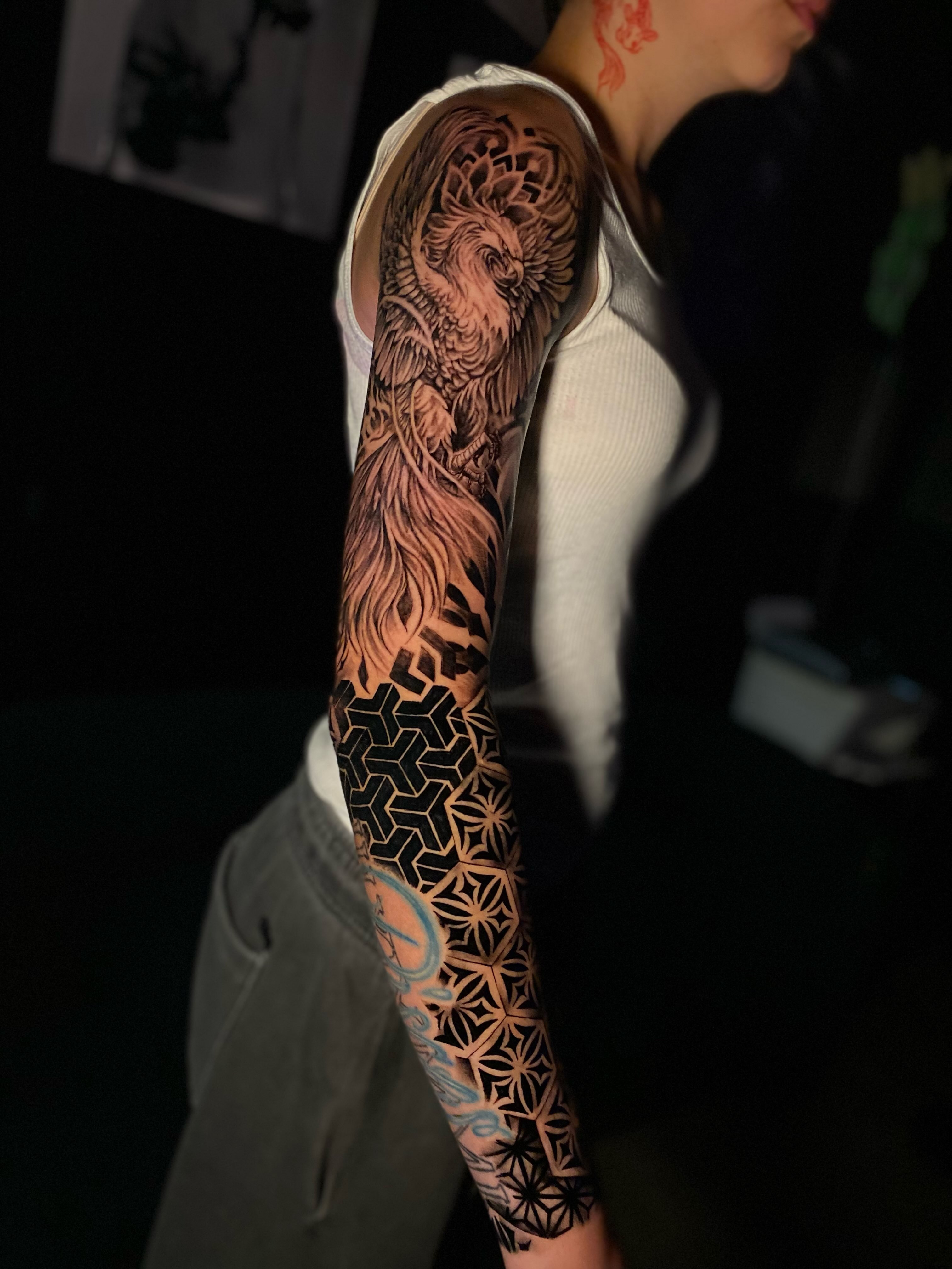 Mythical creature geometric tattoo on the upper arm by Tattoo Artist
