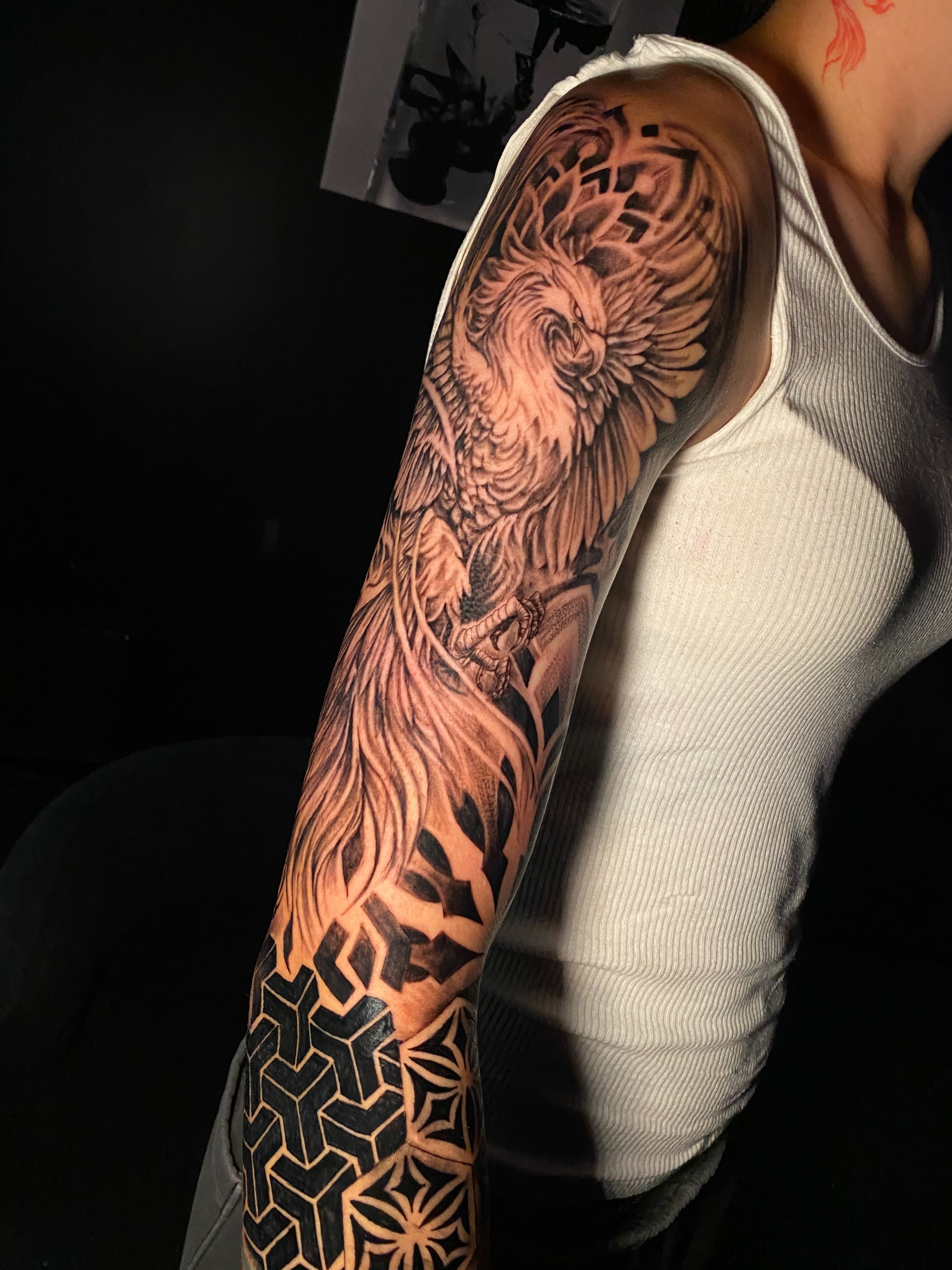 Phoenix realism tattoo on the upper arm by Tattoo Artist
