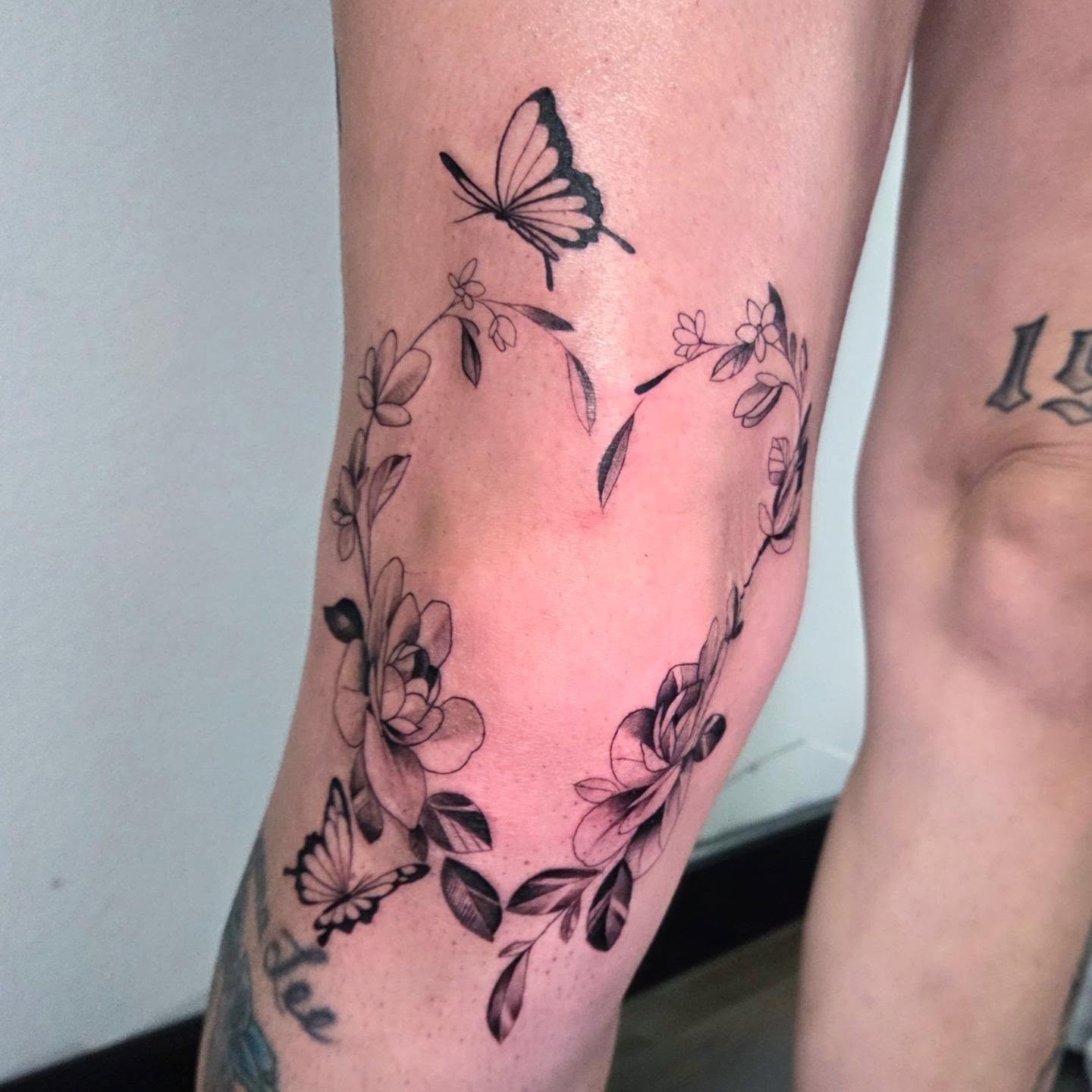 Flower wreath with butterflies black and grey tattoo on the calf by Yvette Cebreros