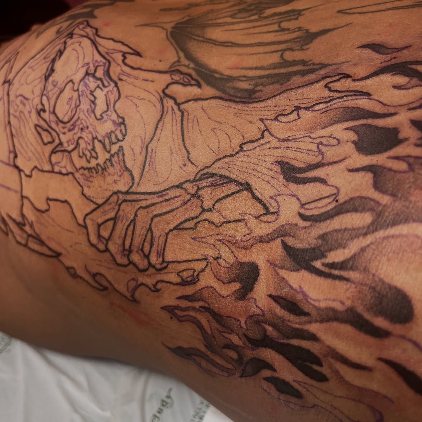 Flaming skull dark realism tattoo on the thigh by Cameron Jenkins
