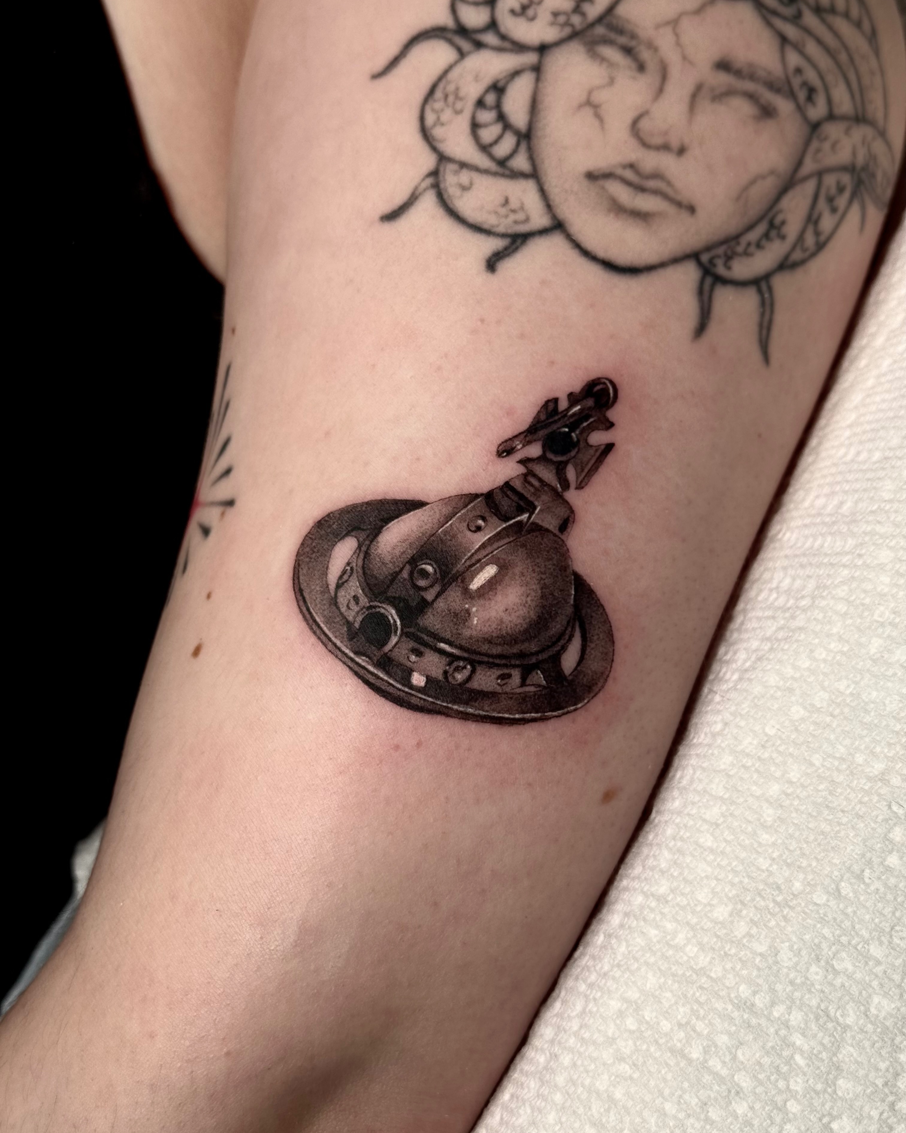 Spaceship black and grey tattoo on the forearm by Em Krieg