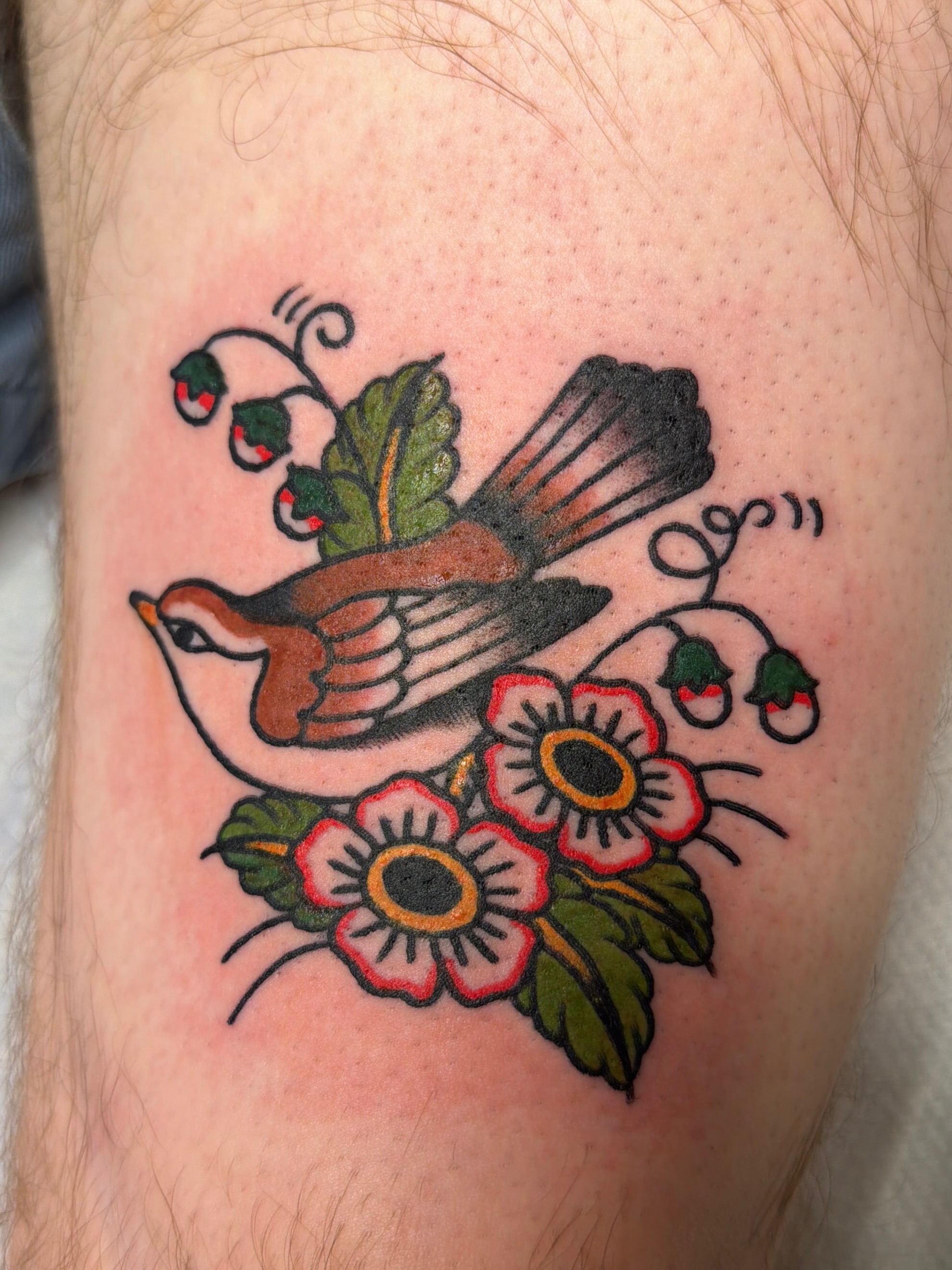 Bird and flowers American traditional tattoo on the forearm by Emma Fox Tattoo