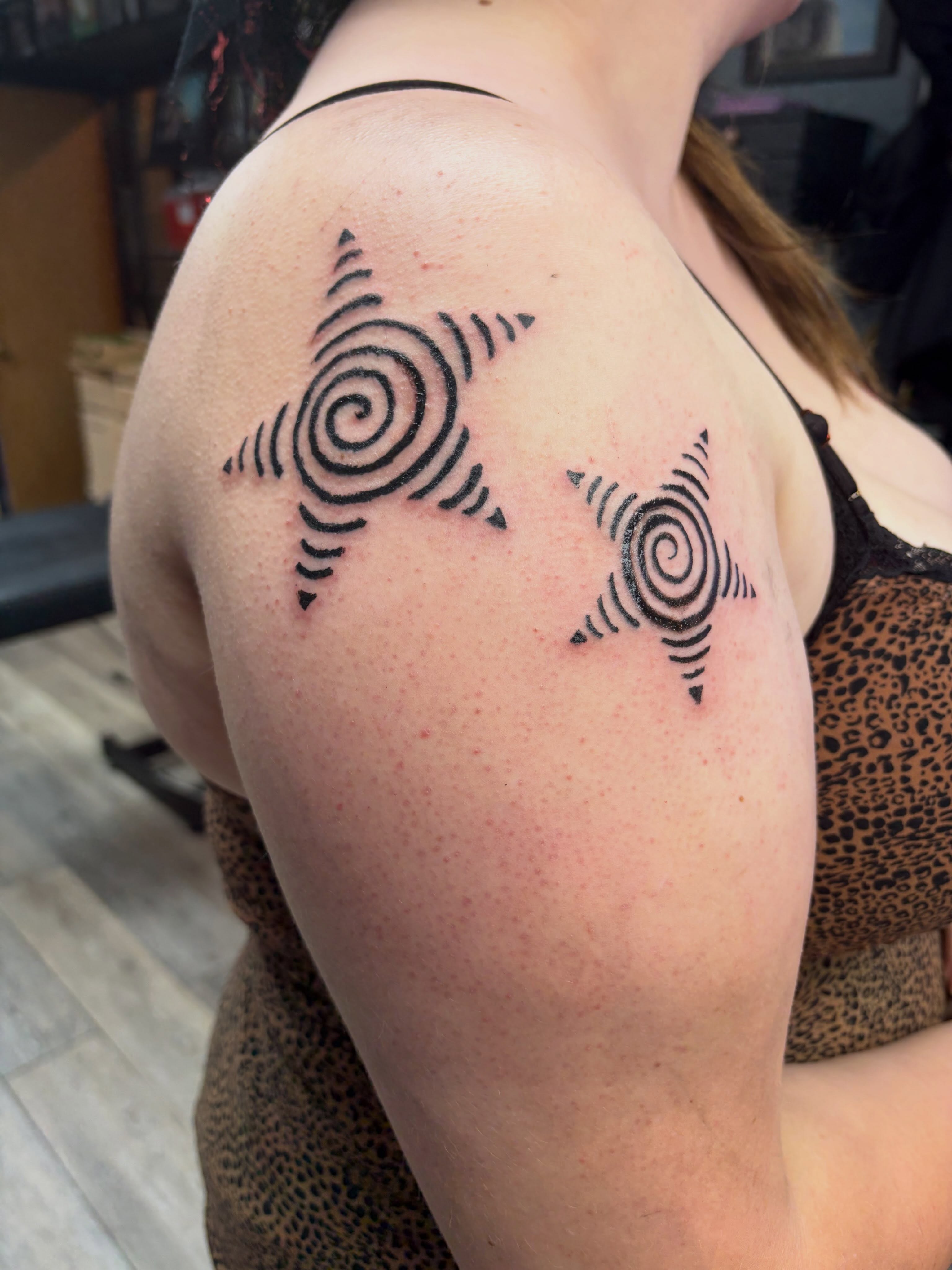Spiral star geometric tattoo on the shoulder by Madison