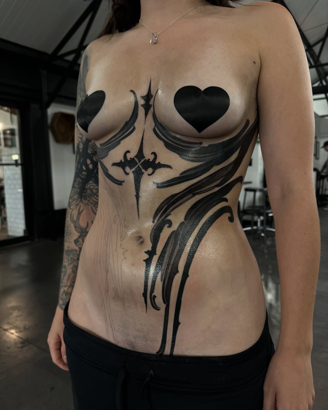 Heart and wings geometric tattoo on the chest by Heather Apgar