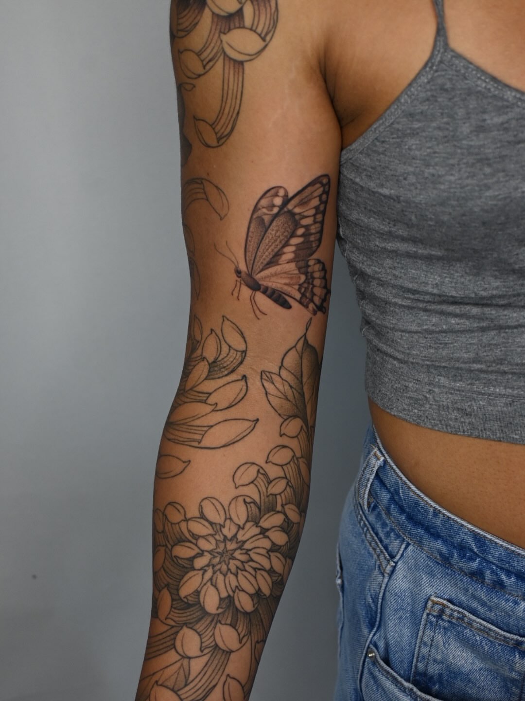 Butterfly and floral black and grey tattoo on the forearm by Simba Nguyen