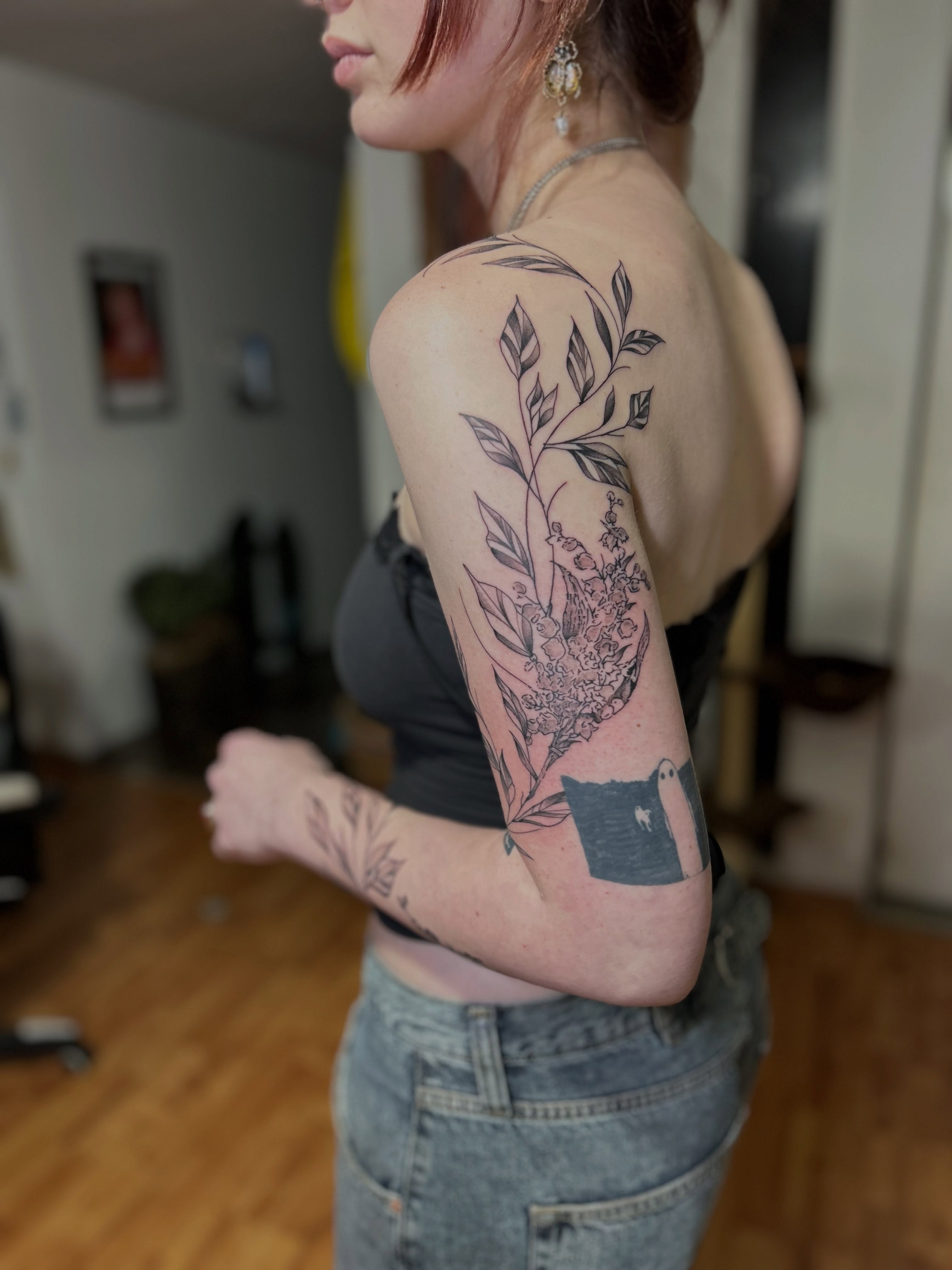 Botanical black and grey tattoo on the upper arm by Barro