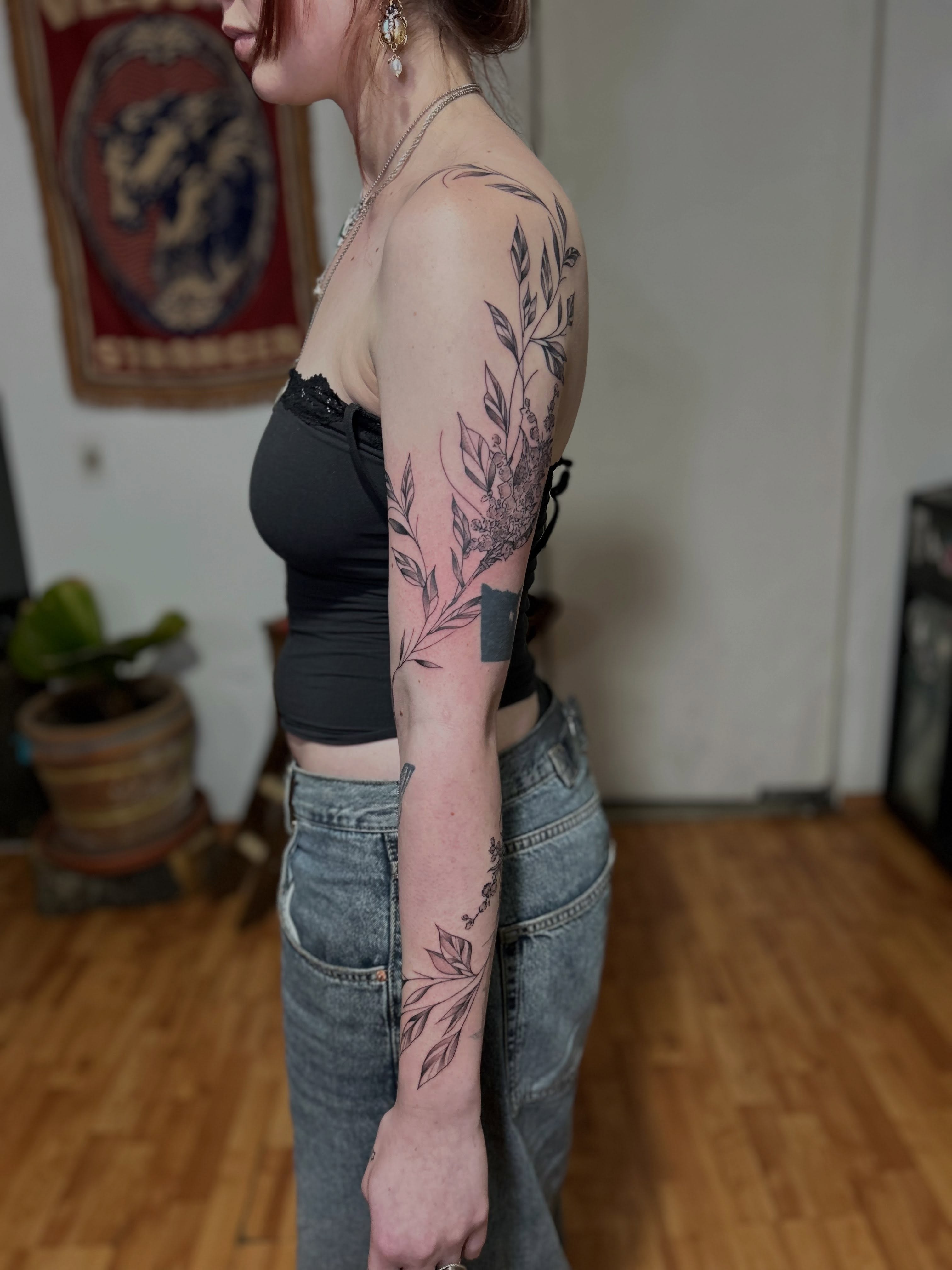 Botanical black and grey tattoo on the upper arm by Barro