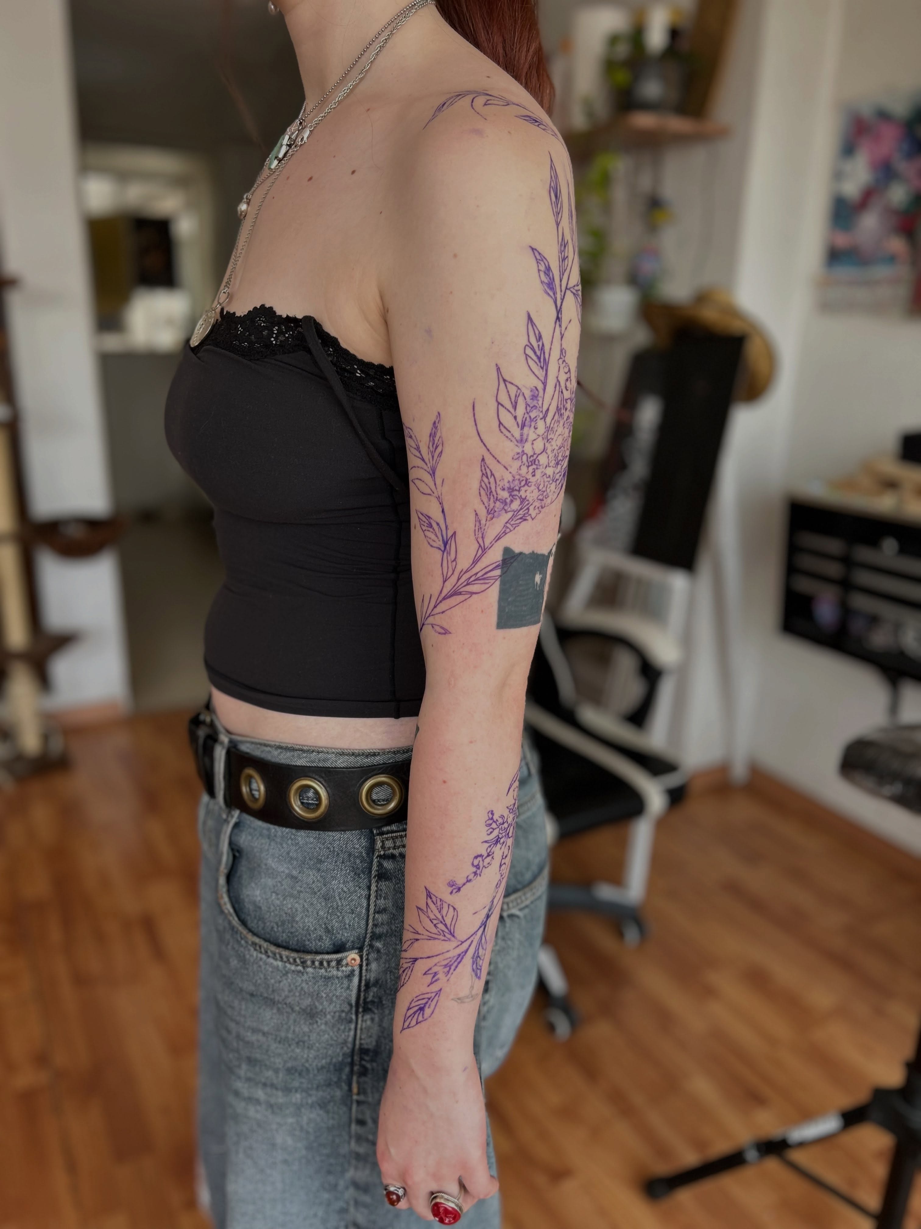Plant fine line tattoo on the upper arm by Barro