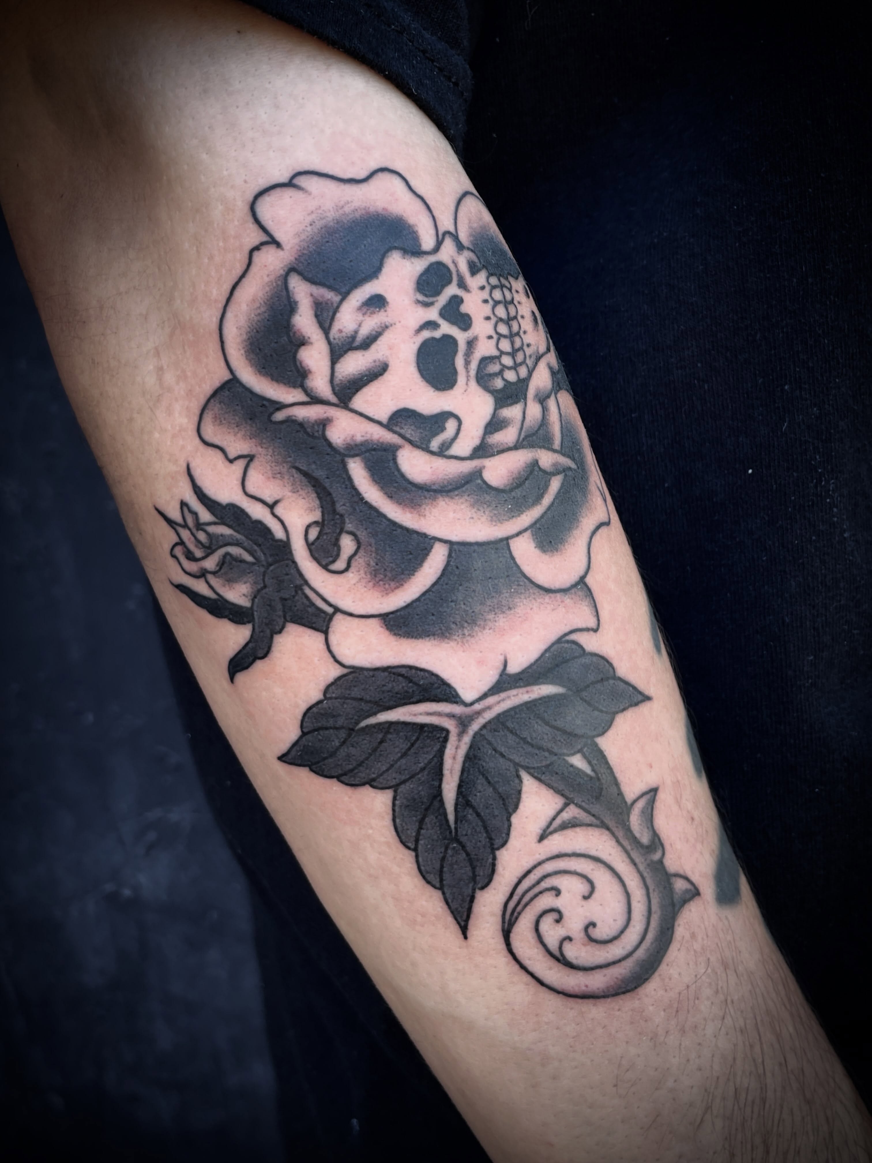 Skull and rose realism tattoo on the forearm by Nick Wallin