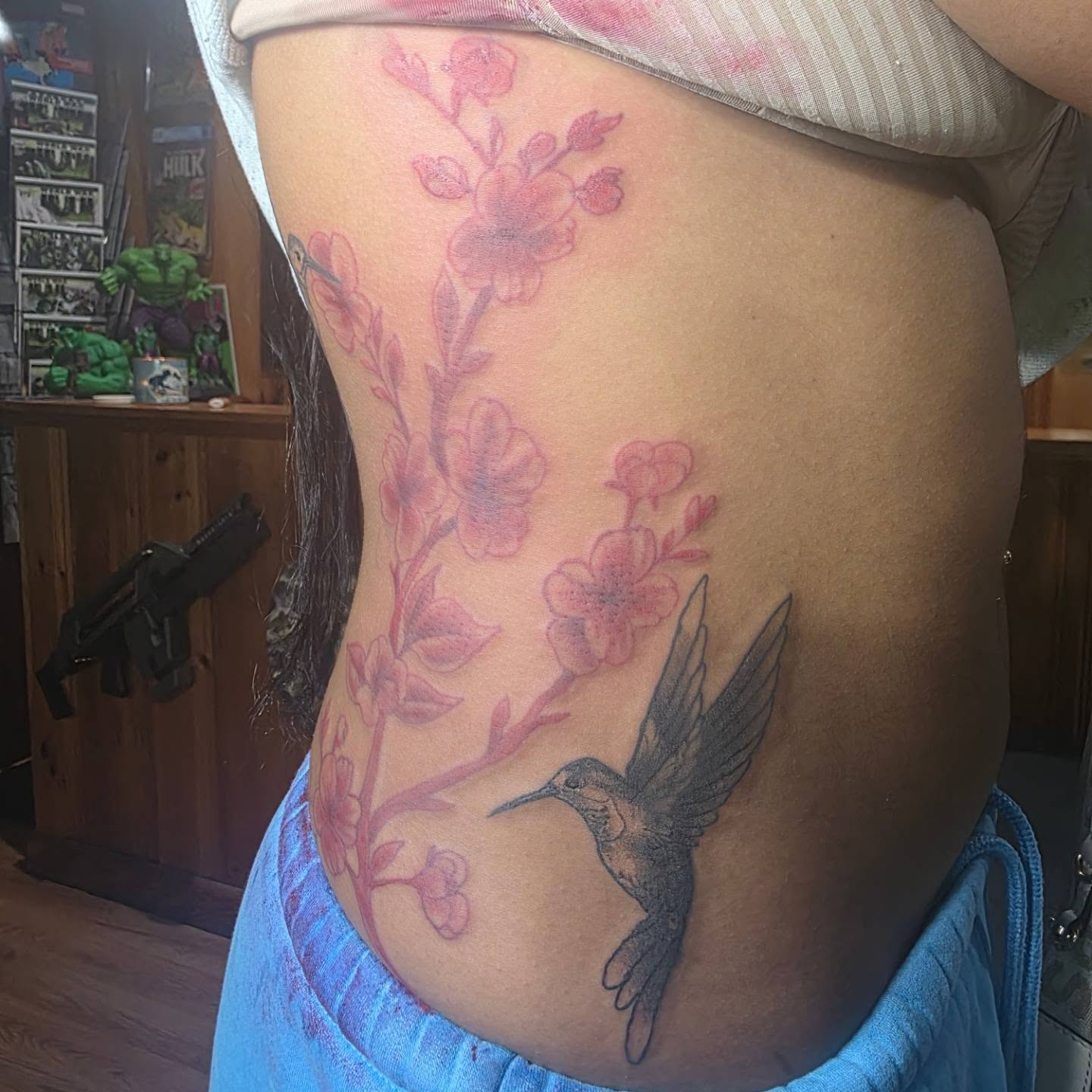 Hummingbird and cherry blossoms black and grey tattoo on the ribs by Rusty Williams