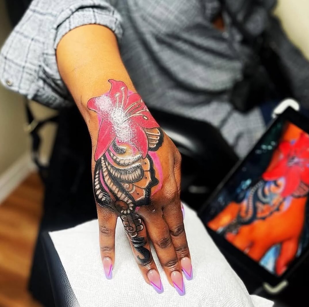Butterfly and flower new school tattoo on the hand by Inkby_larry