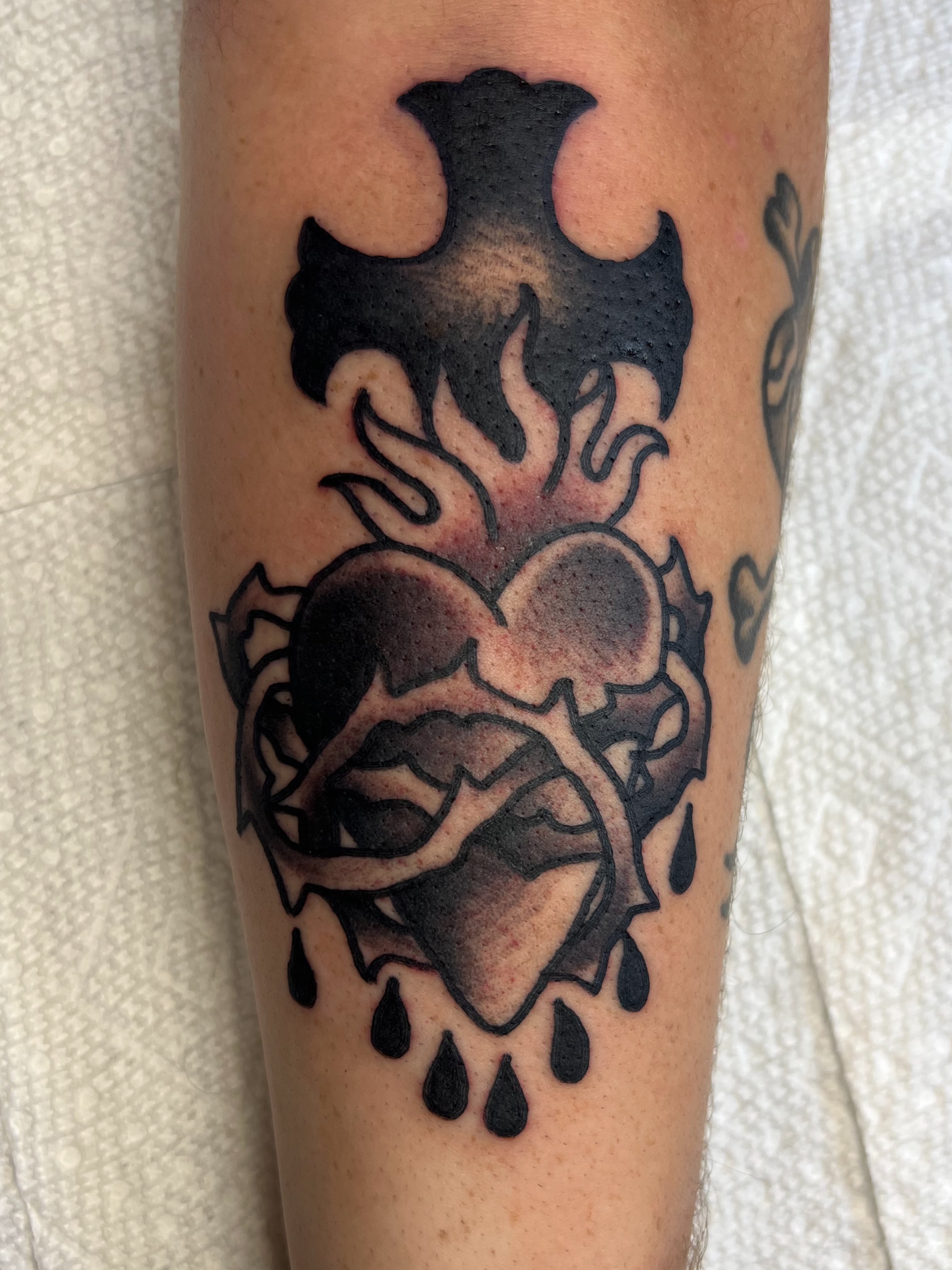 Heart with flames black and grey tattoo on the forearm by Tattoo