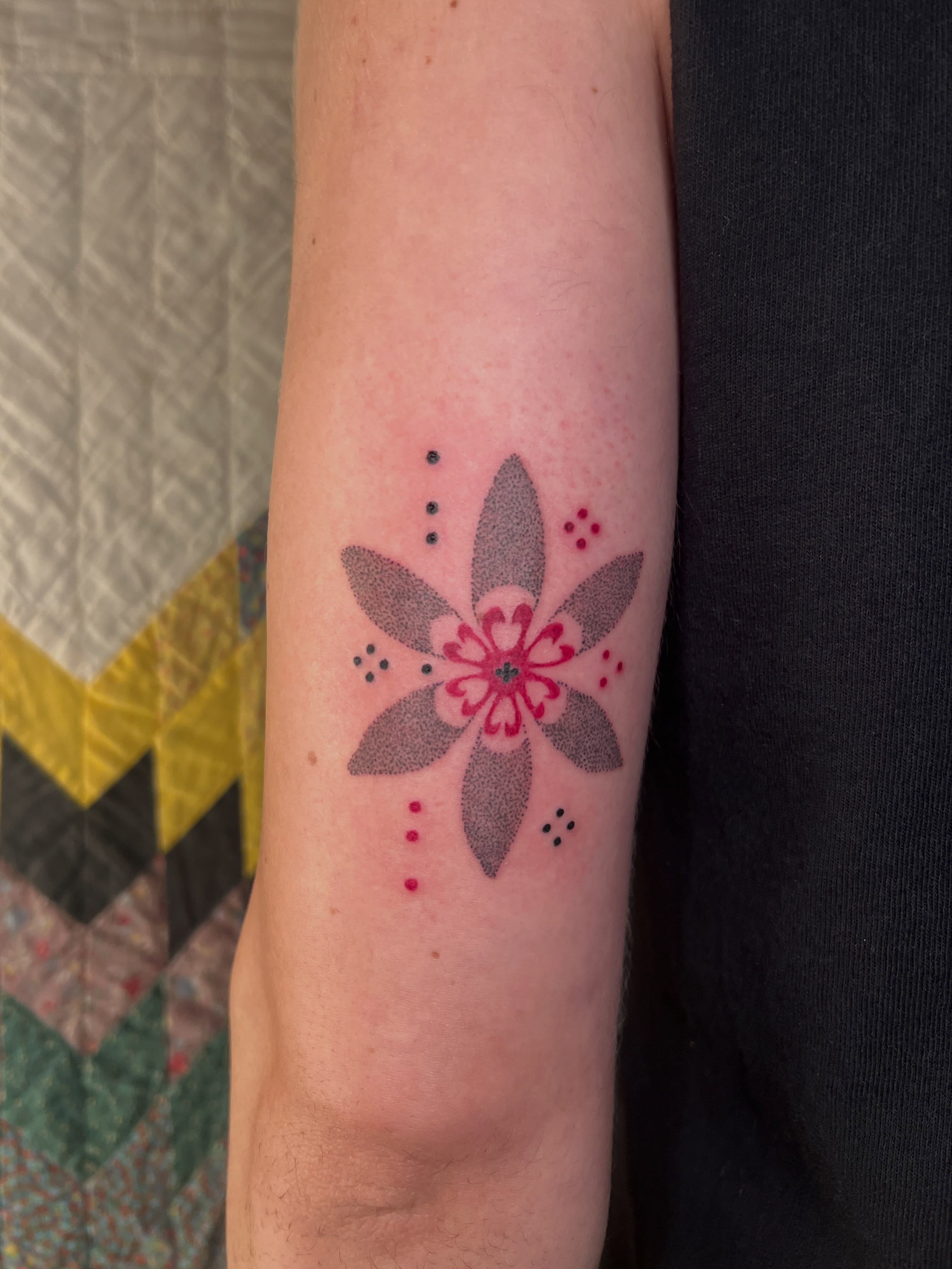 Geometric flower dotwork tattoo on the forearm by faith