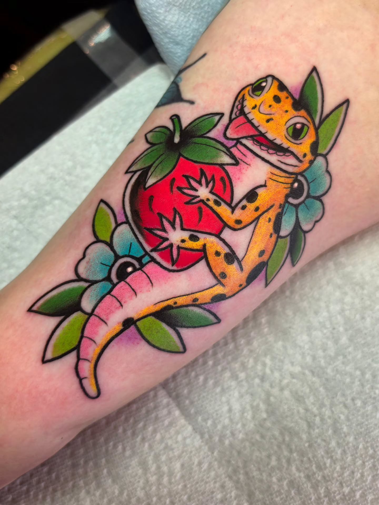 Gecko and strawberry American traditional tattoo on the forearm by 𝔎𝔦𝔯𝔞 𝔅𝔦𝔰𝔥𝔬𝔭