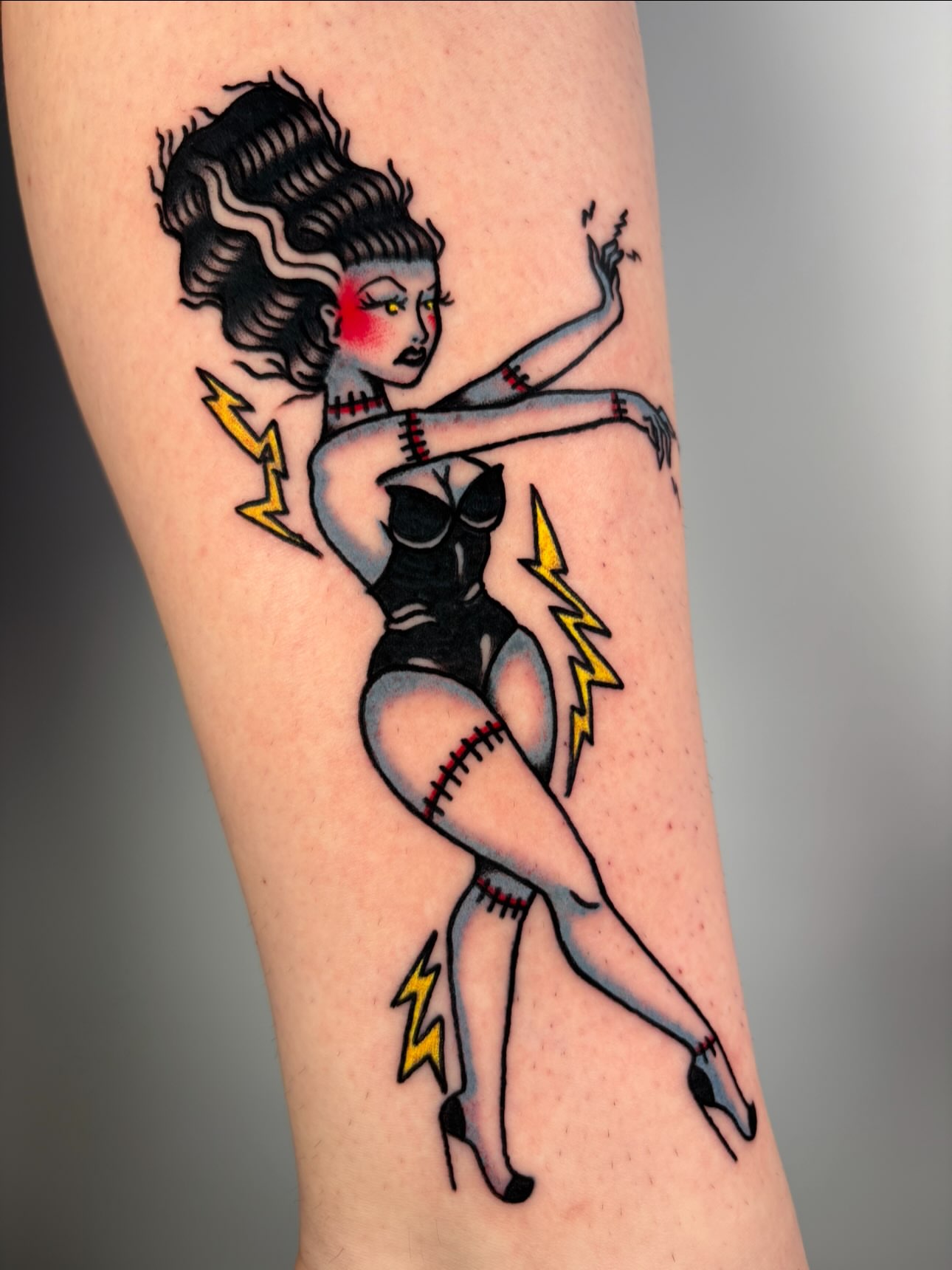 Pin-up girl American traditional tattoo on the forearm by Lorelei